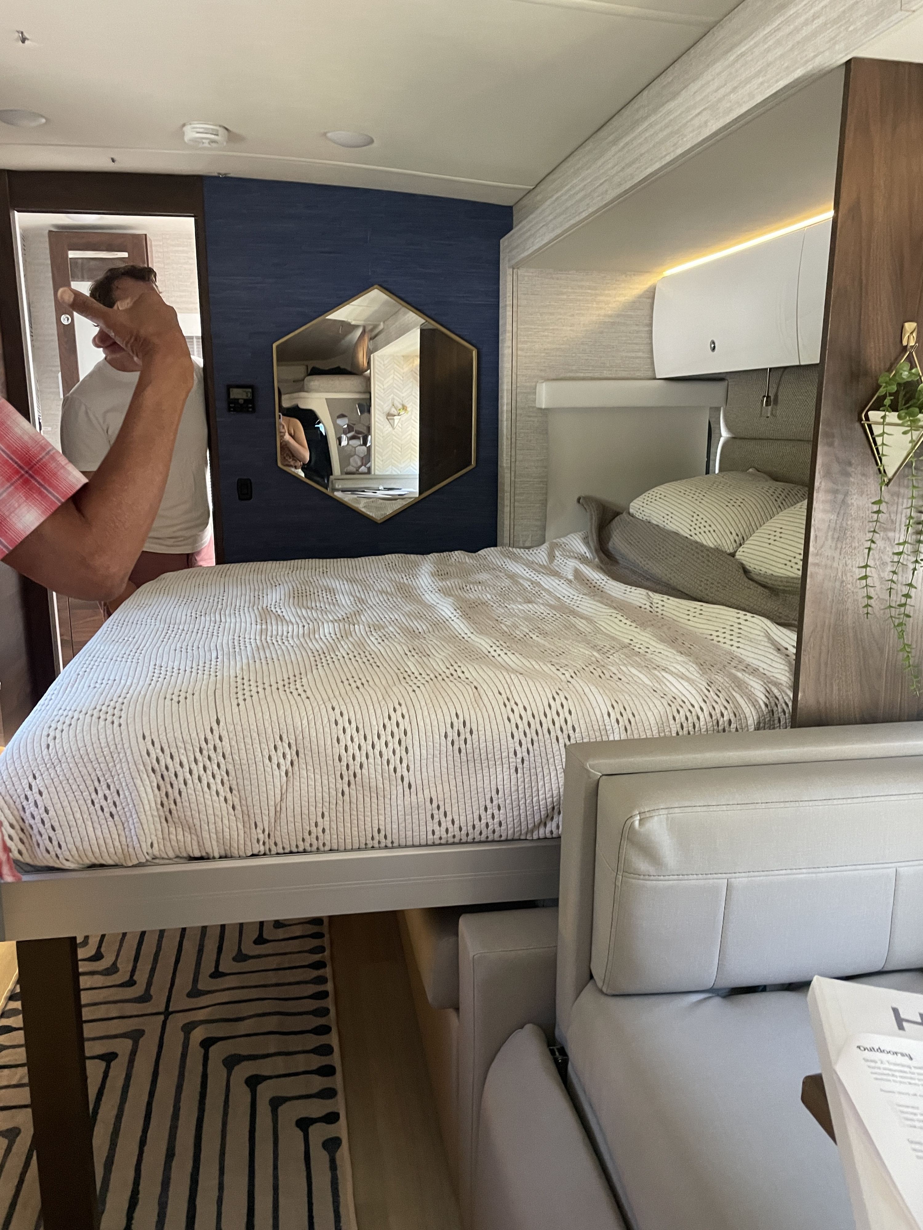 RV rental: Modern interior with a bed, light-toned sofa, blue accent wall, and hexagonal mirror.. Winnebago View 2021