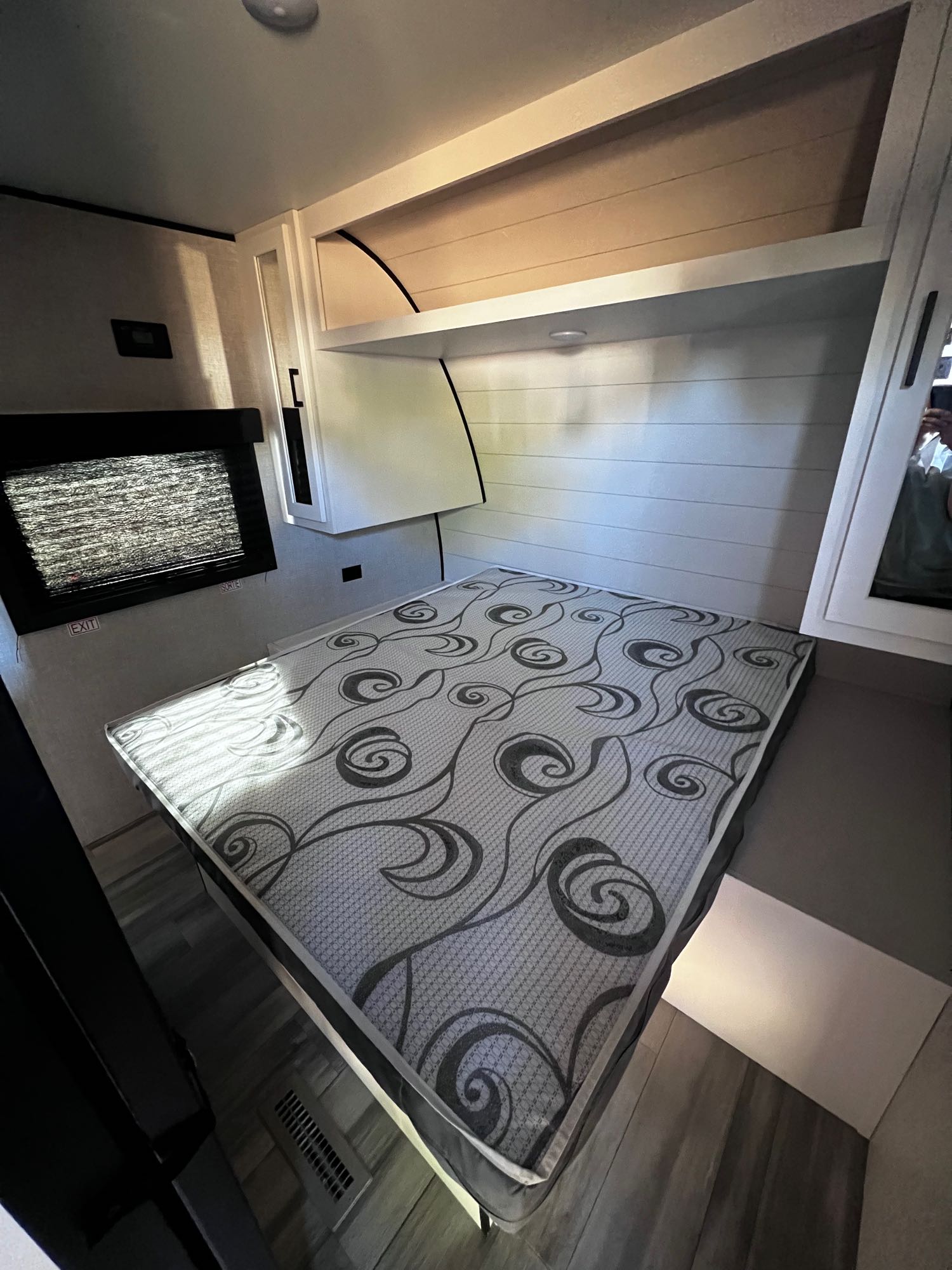 Inside this RV rental: a compact bedroom with a patterned mattress, built-in storage, and an emergency exit window.. Highland Ridge RV Open Range 2024
