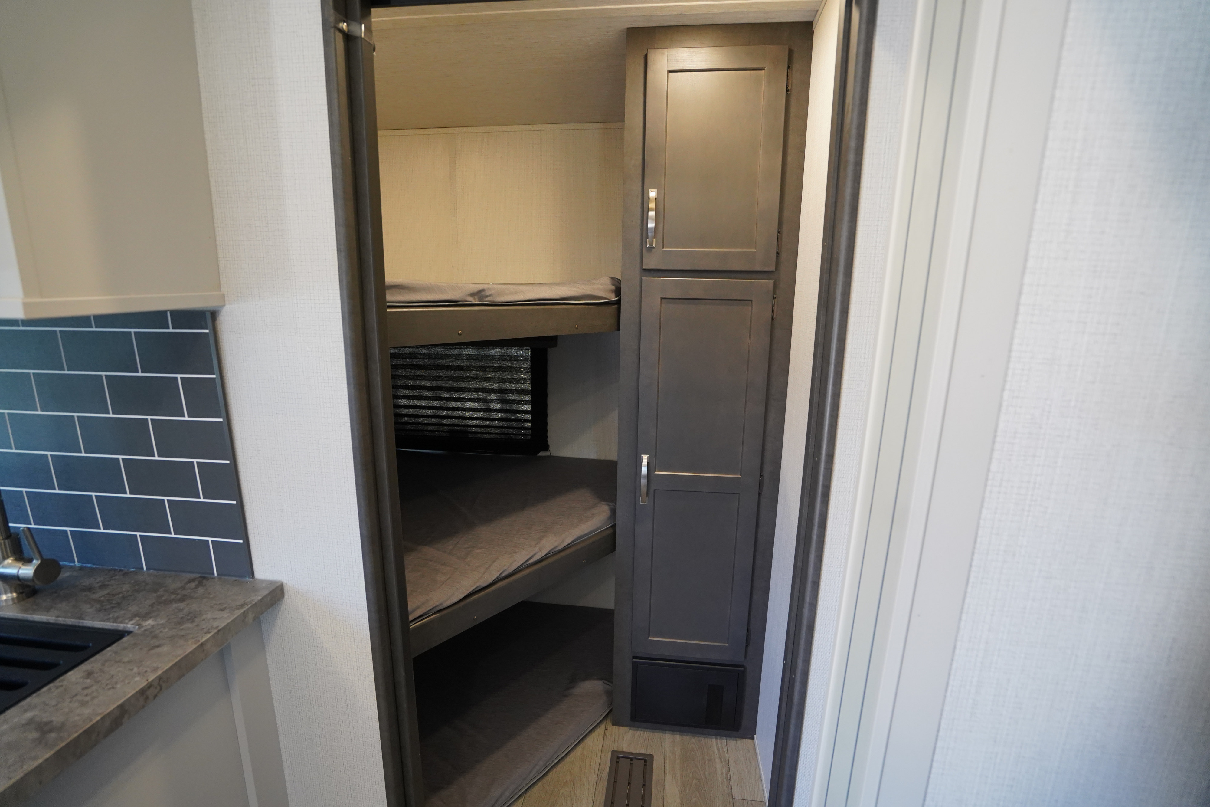 Step inside this RV rental showcasing bunk beds, a compact kitchen, and built-in storage solutions.. Keystone Cougar 2024