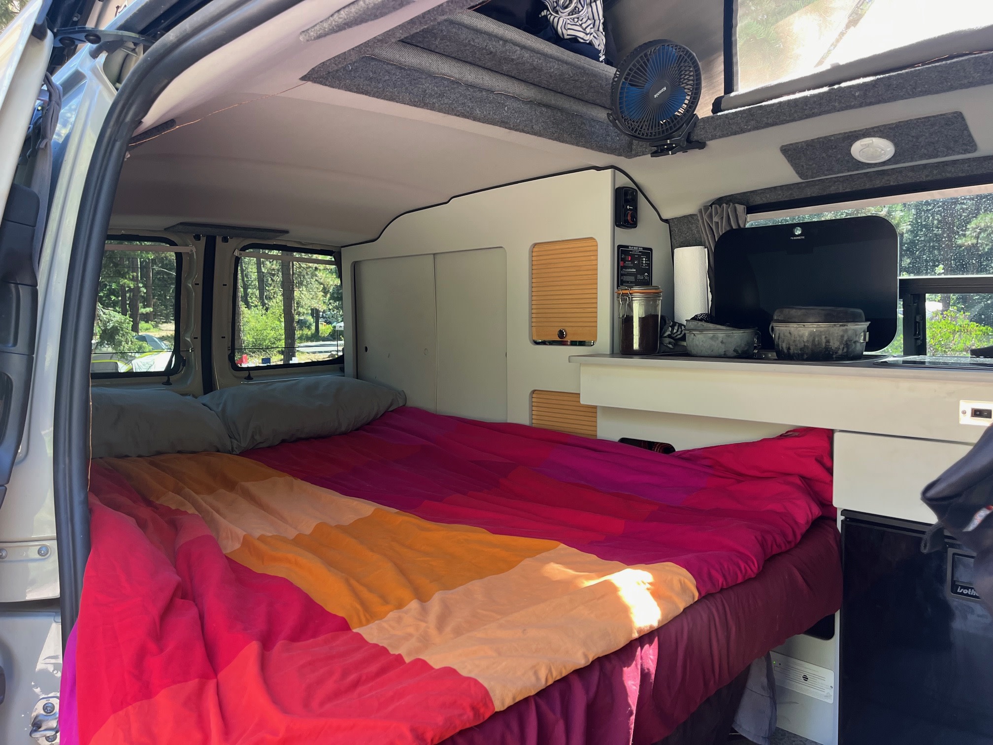 Cozy camper van interior with colorful bed & built-in kitchen. Ideal for an RV rental getaway.. Mercedes-Benz Metris by GTRV 2019