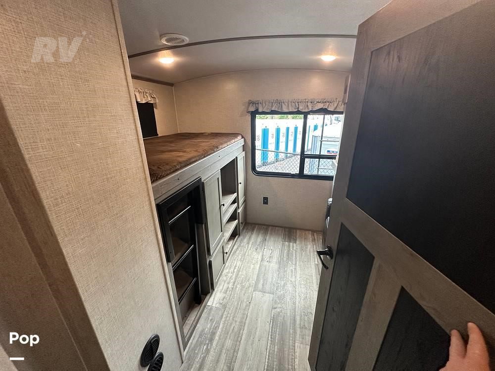 RV rental bunkhouse interior: upper bunk bed, built-in storage shelves, and a window. Ready for adventure.. Keystone RV Outback 2021
