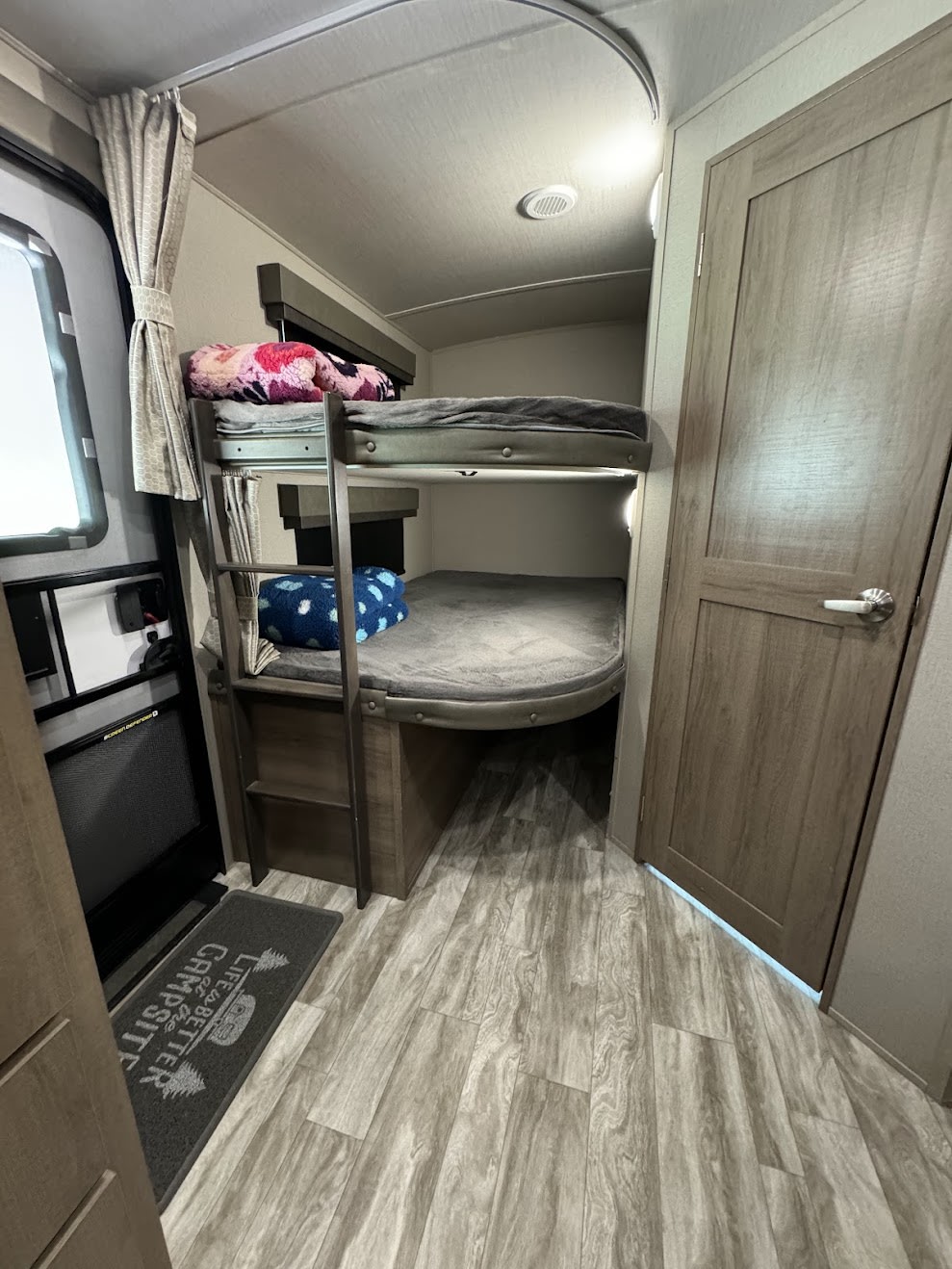 RV rental interior with bunk beds (upper & lower), ladder, and wood-look floor. Provides comfortable sleeping for families.. Grand Design Imagine 2021