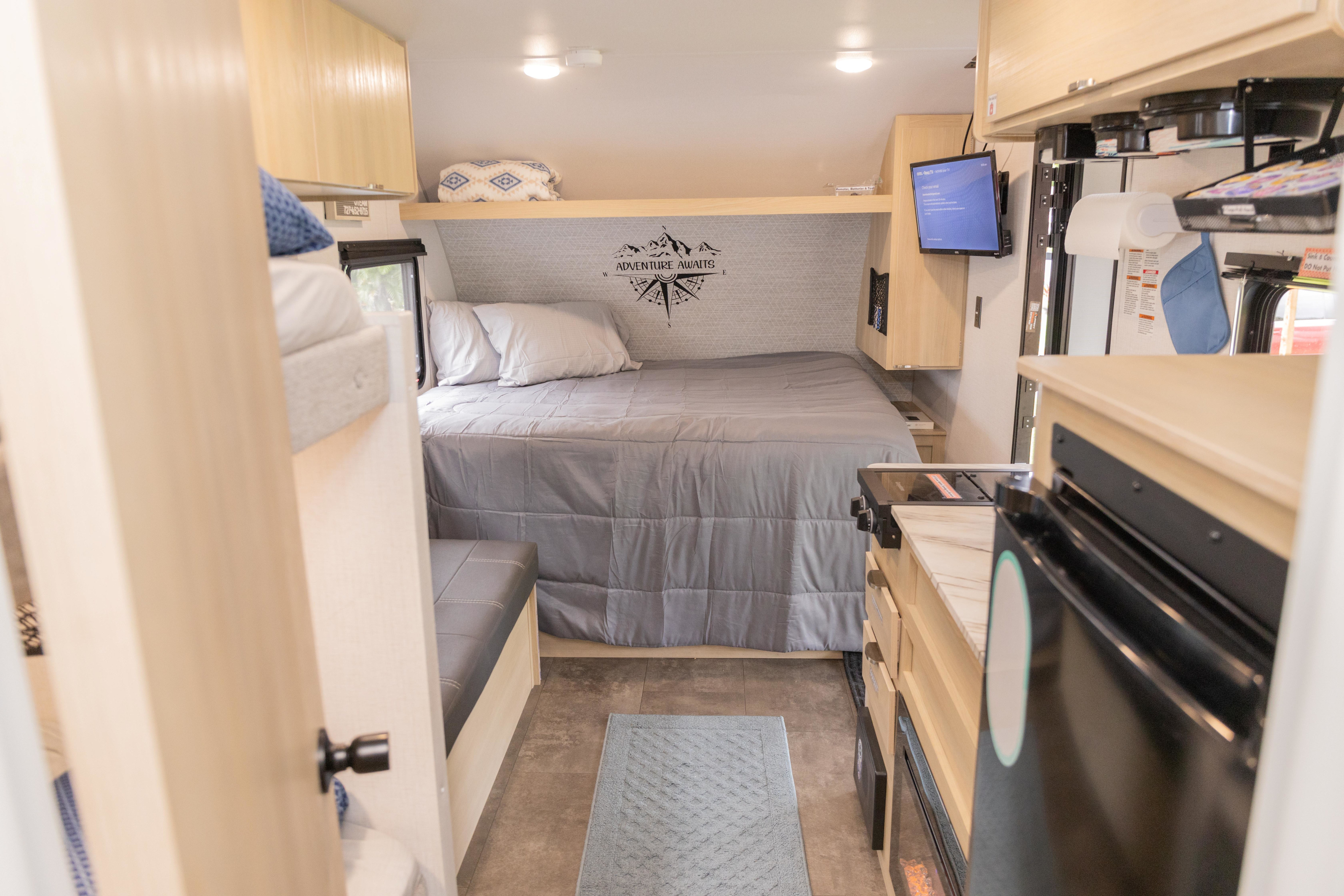 Cozy RV rental interior shows a bed, bunk, kitchen, and dinette, perfect for travel adventures.. Forest River Salem FSX 2024