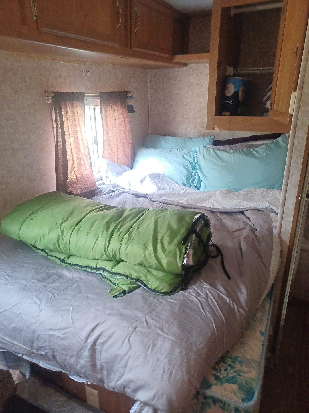 Cozy RV rental interior: bedroom with a comfy bed, light blue pillows, and a green sleeping bag. Ideal for camping trips!. Extreme RVs Extreme 2008