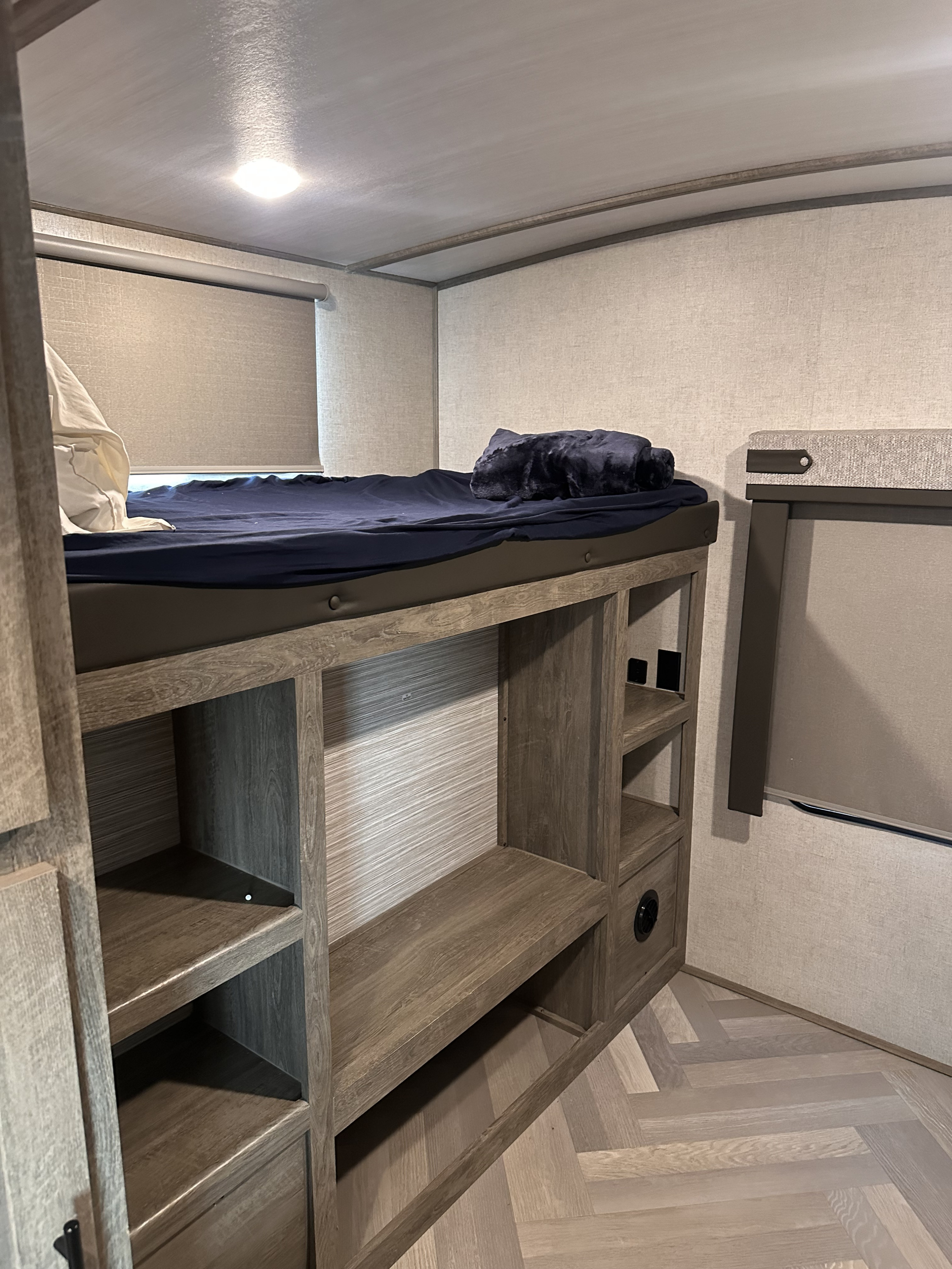 RV rental bunk beds with built-in storage and sleek wood finishes, perfect for compact living.. Forest River Wildwood Heritage Glen 2021