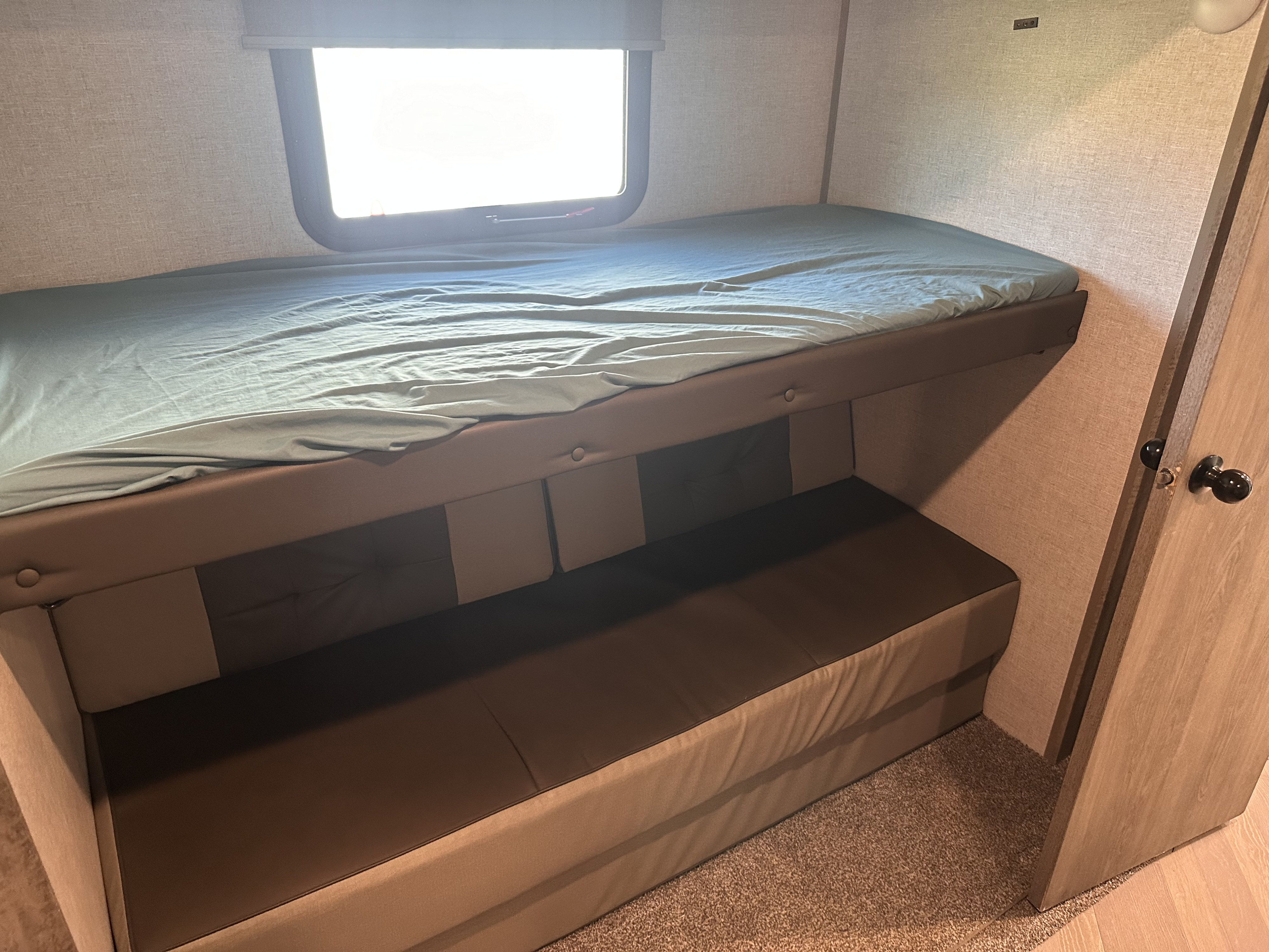 RV rental interior features bunk beds with a lower convertible couch, ideal for family travel.. Forest River Wildwood Heritage Glen 2021