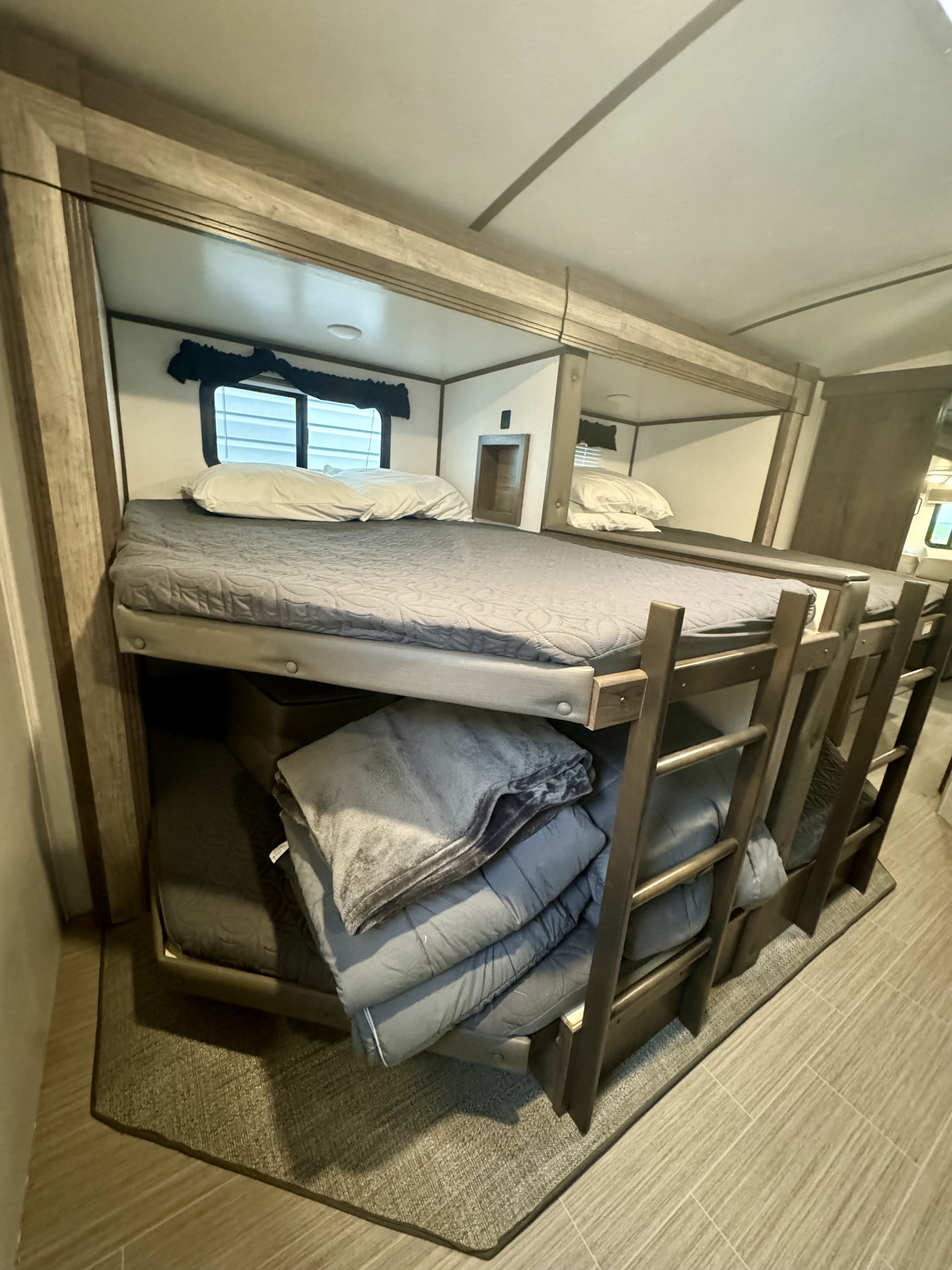 Comfortable bunk beds in an RV rental, perfect for family travel and extra sleeping space.. Keystone RV Passport GT 2021