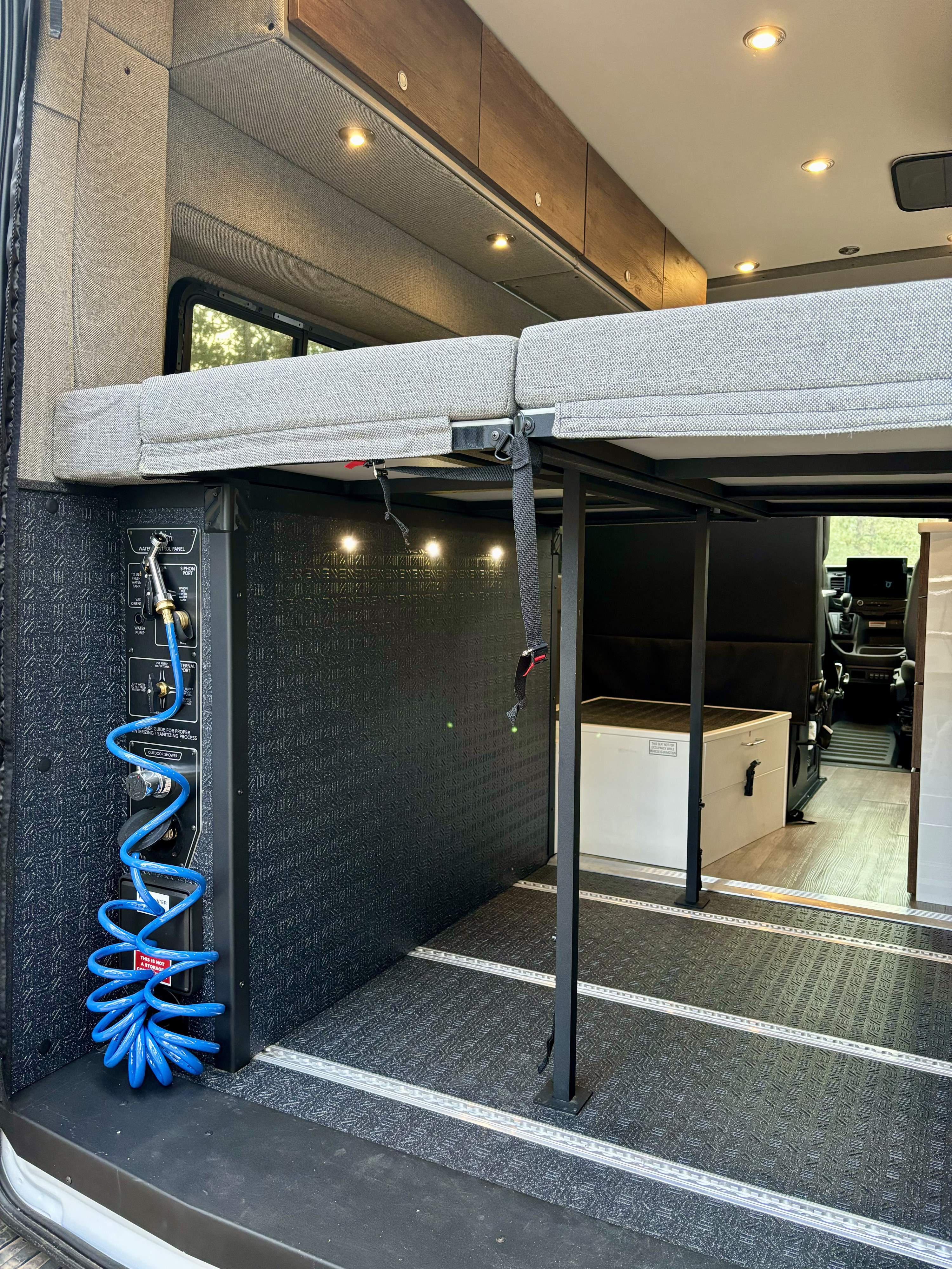 Inside this RV rental: versatile elevated bed, outdoor shower, & organized utility panel for your adventures.. Storyteller Overland Storyteller Overland Class B 2023