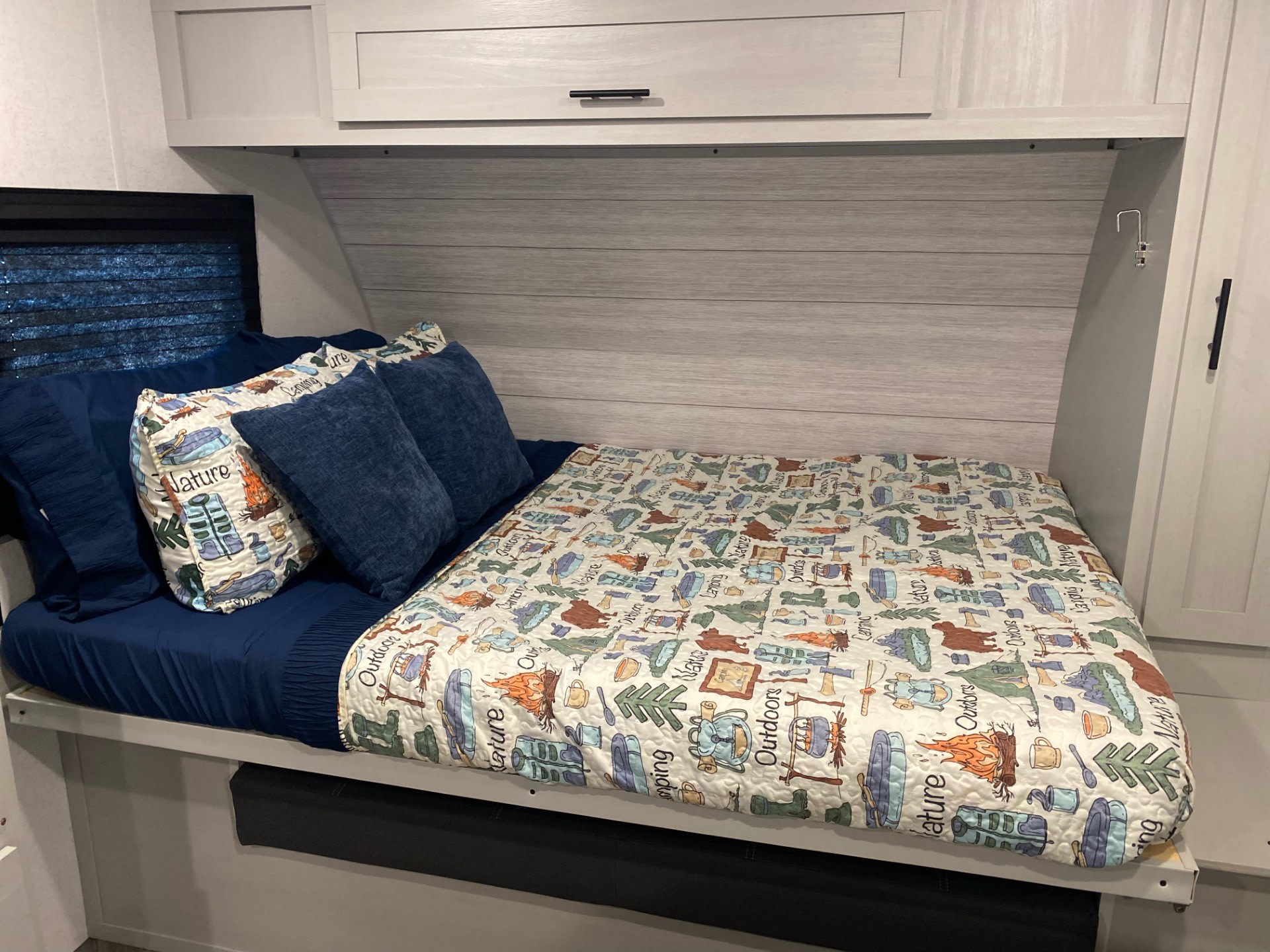 Cozy RV rental bedroom with camping-themed bedding, featuring illustrations of nature, perfect for travel adventures.. Forest River Salem FSX 2022