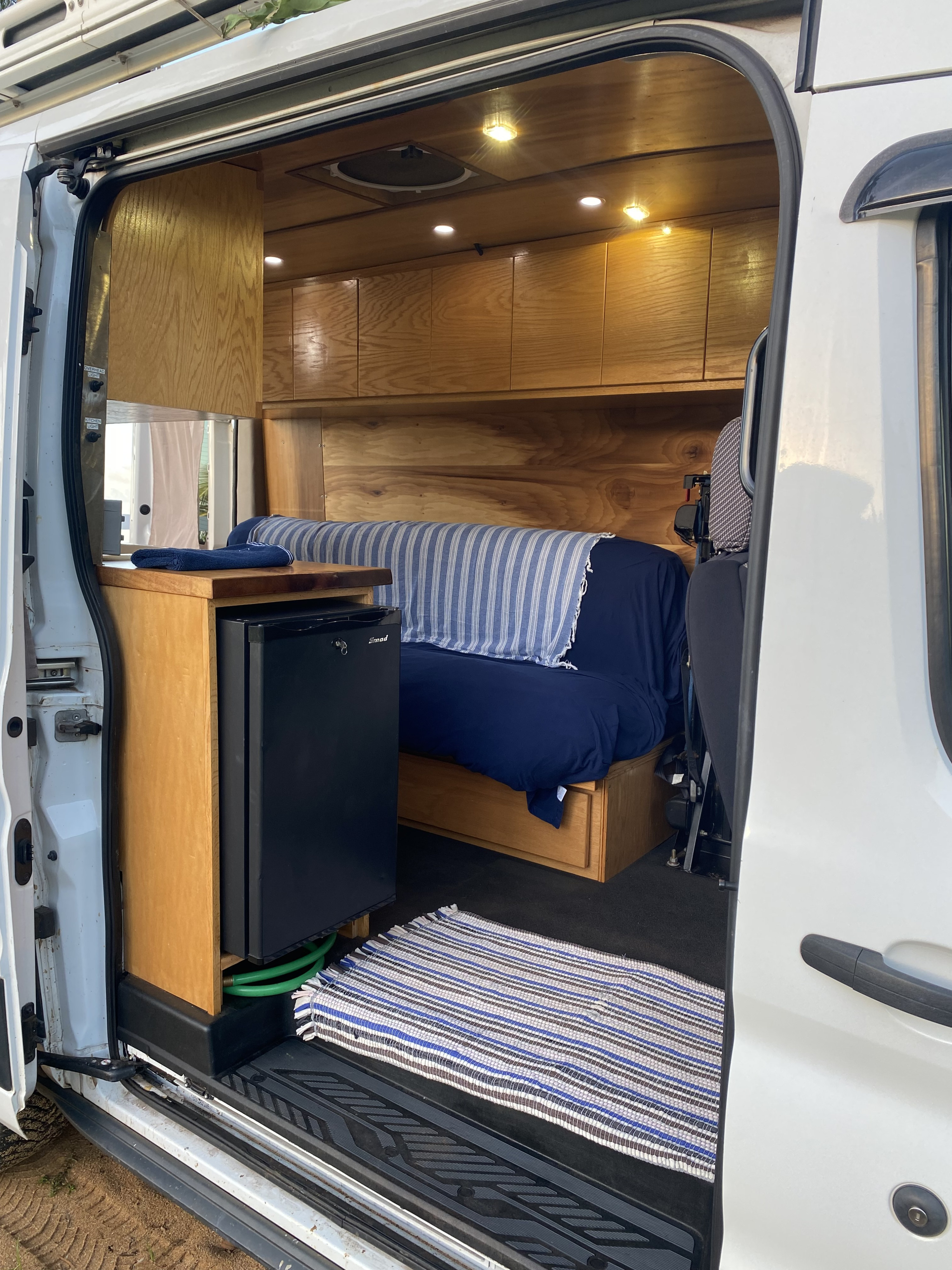 RV rental: Step inside this custom camper van, featuring a mini-fridge, wooden cabinets, and a bed.. Ford Transit 2018