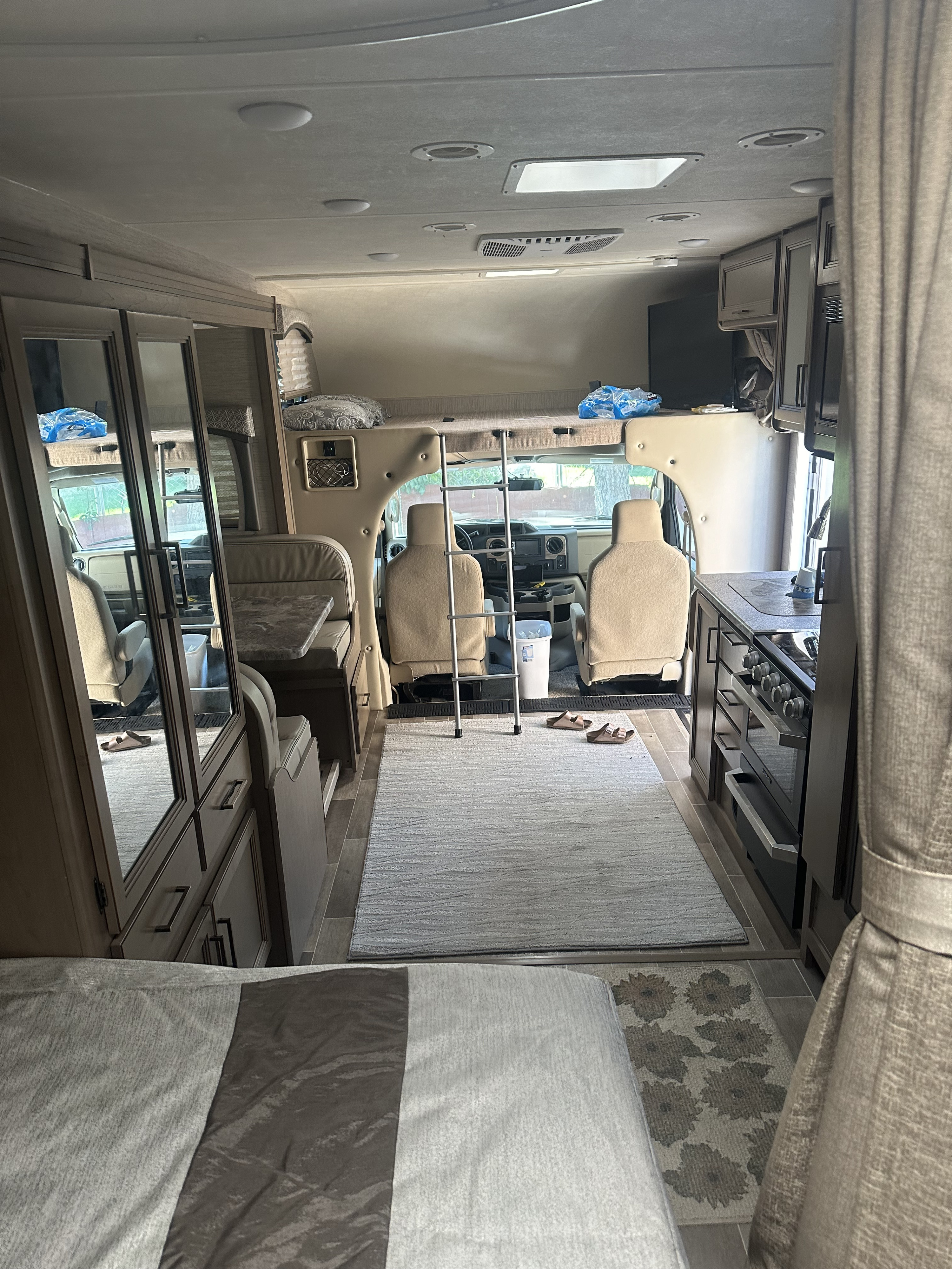 RV rental interior view: kitchen, dinette, bedroom area, and overhead bunk. Great motorhome for travel.. Thor Chateau 2021
