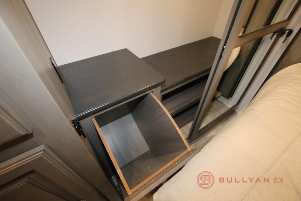 RV rental bedroom interior showcasing smart storage: a bedside table with an open cubby and shelves. Ideal for compact living.. Keystone RV Montana 2023