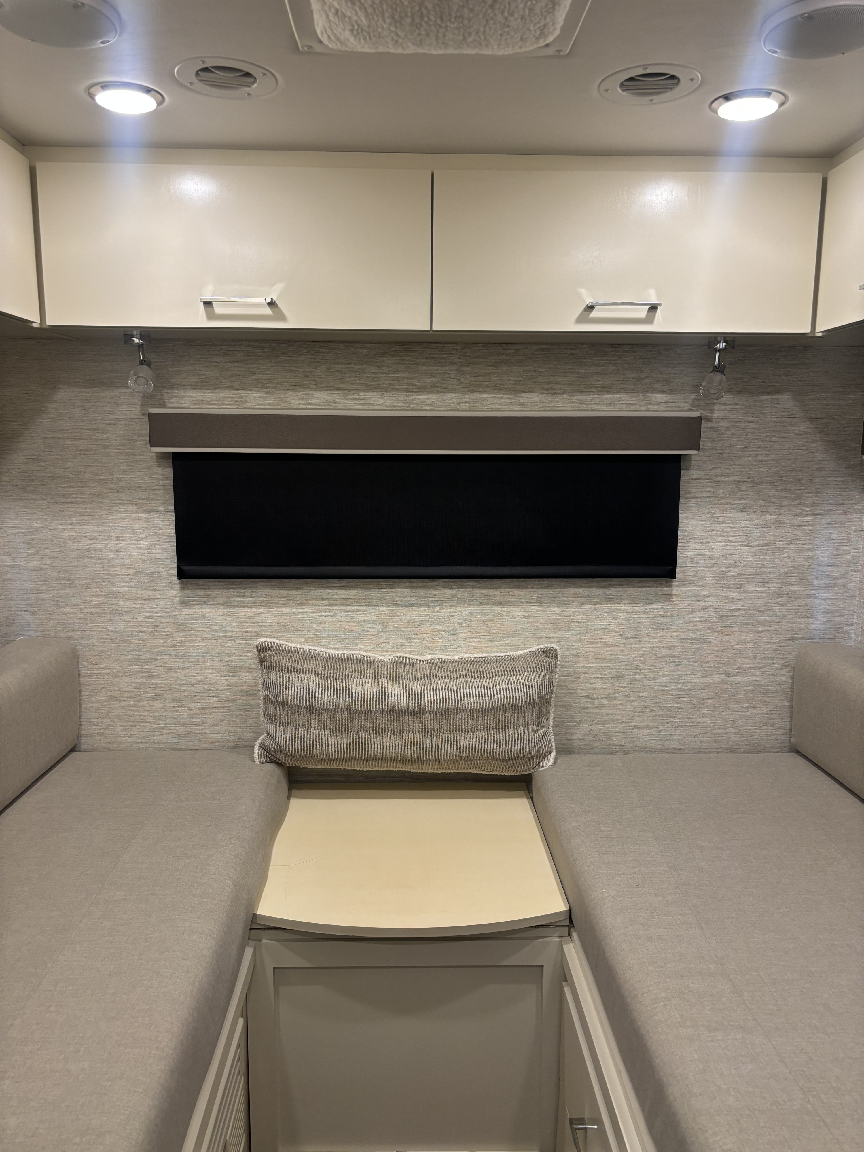 RV rental living space with dual upholstered benches, a central table, overhead cabinets, and a window blind.. Wayfarer Wayfarer Motorhome 2021