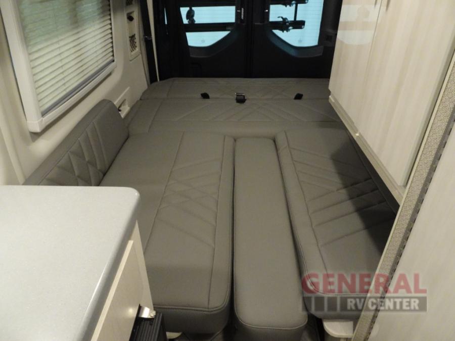 This RV rental features a versatile gray interior with convertible seating that forms a comfortable bed for travel.. Thor Sanctuary 2024