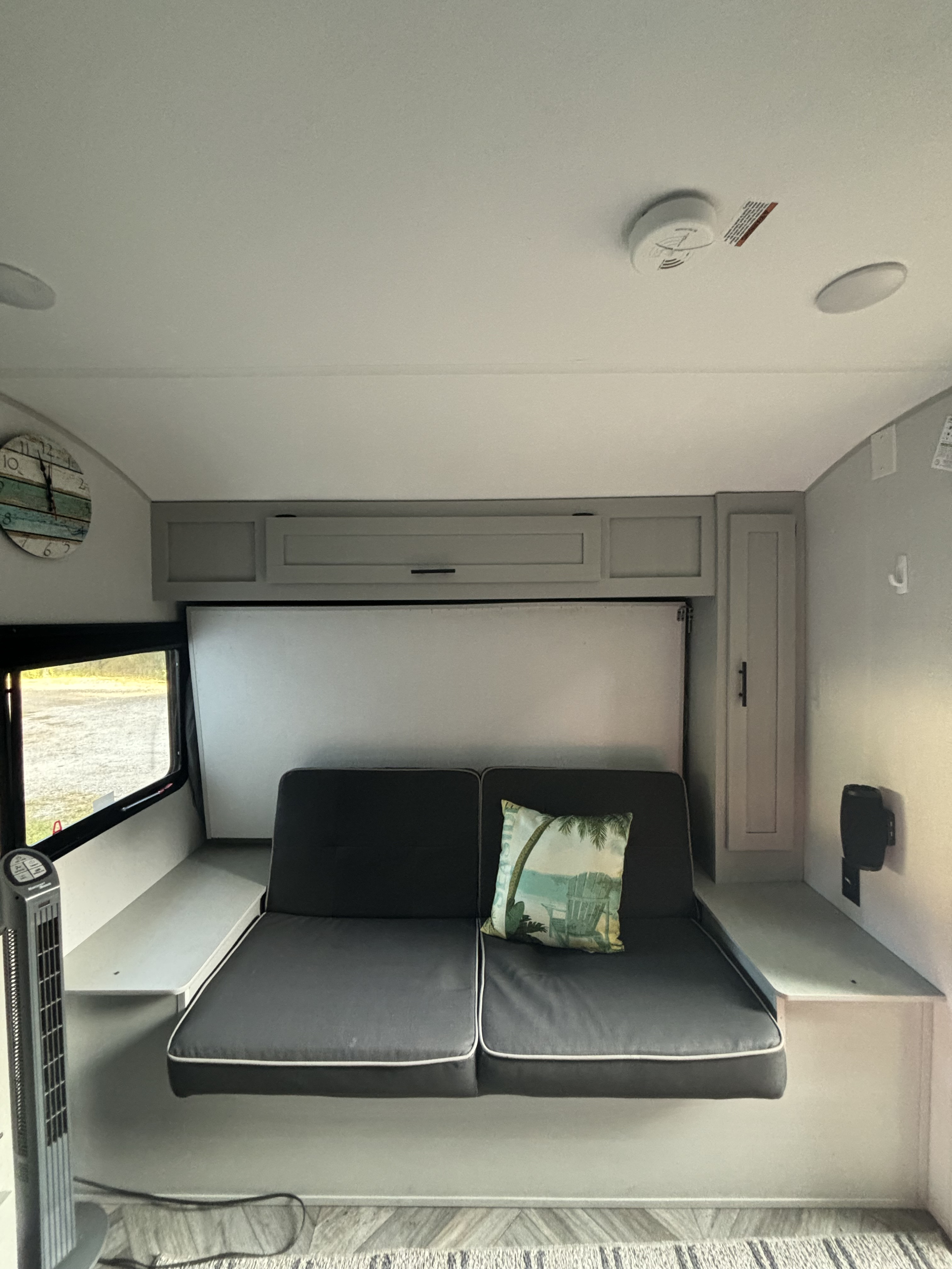 Cozy RV rental interior featuring a sofa, overhead cabinets, and clever space-saving design for comfortable travel.. Forest River Wildwood FSX Plantium 2022