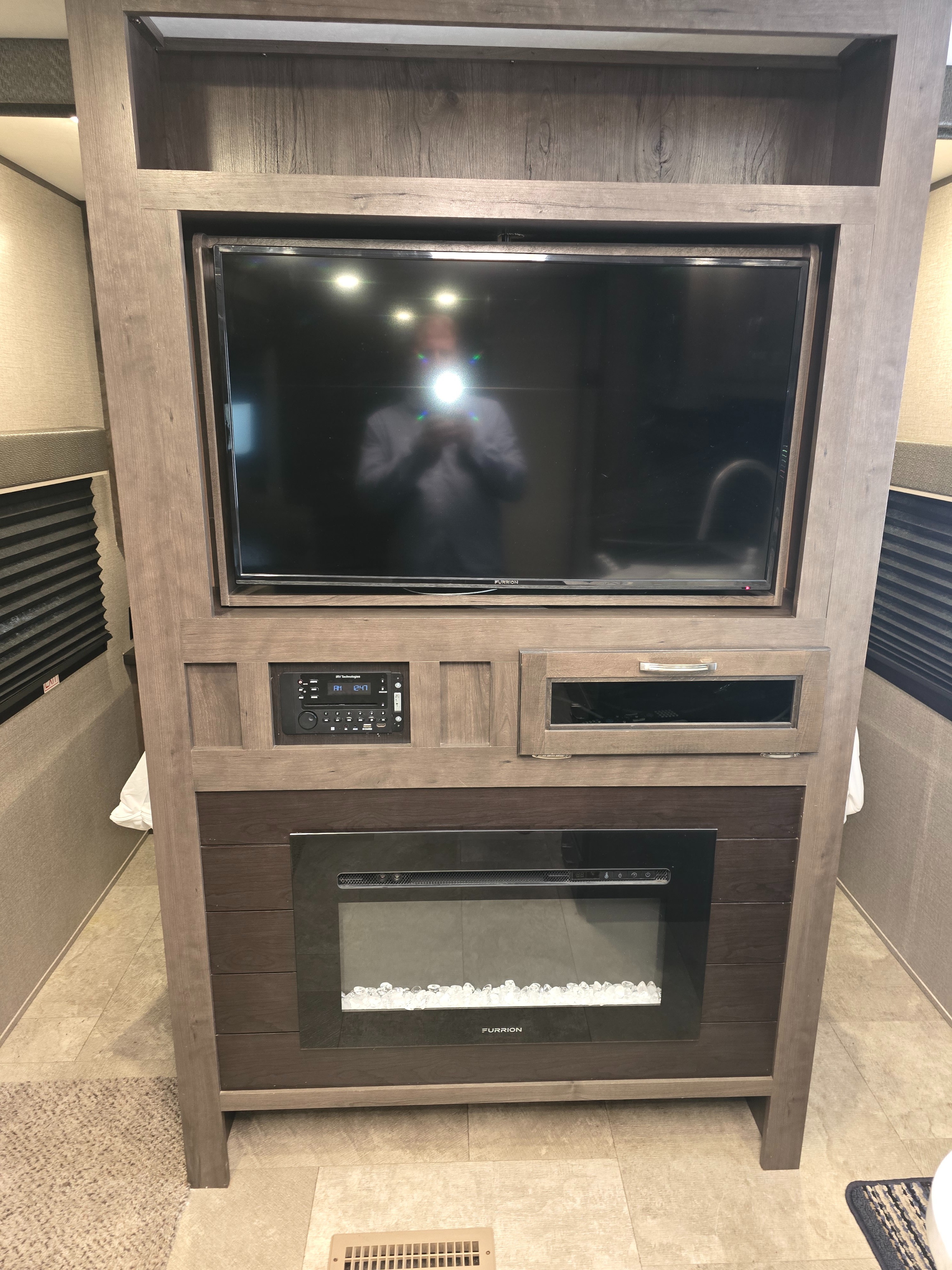 Modern RV rental interior featuring a built-in entertainment center with a TV, stereo, and electric fireplace for cozy living.. Jayco Jay Flight 2020