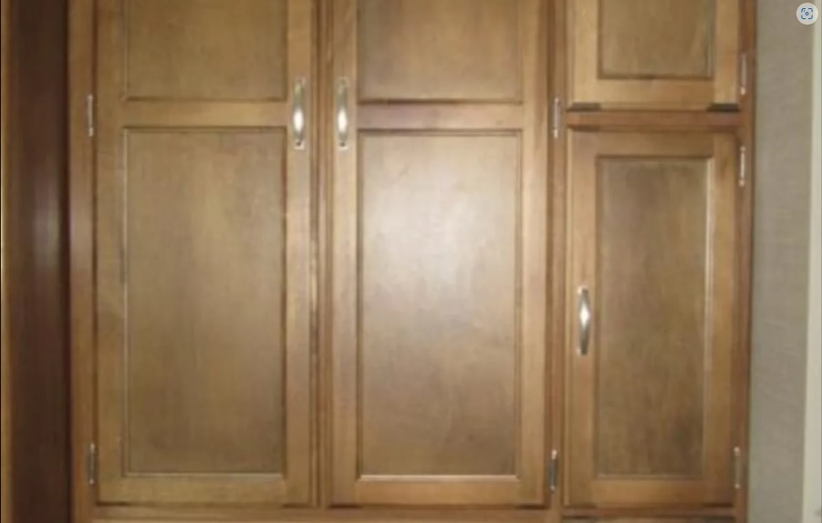 Multiple wooden storage cabinets with silver handles, showcasing typical interior storage in an RV rental.. Keystone Springdale 2016