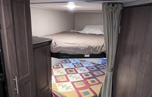 Cozy RV rental bunk beds offer comfortable sleeping in this camper interior, ideal for family travel adventures.. Keystone RV Hideout LHS 2019
