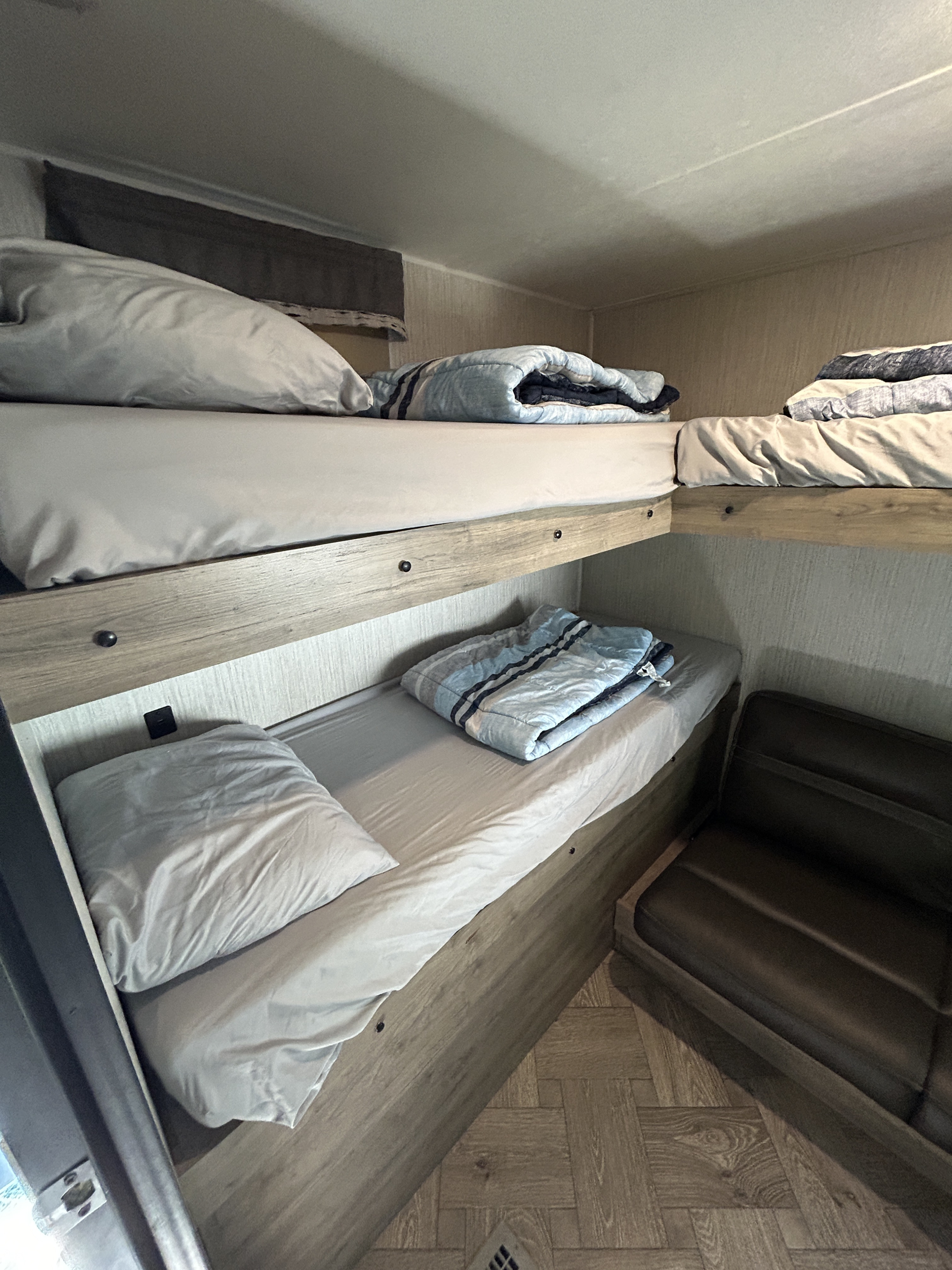 Cozy RV rental interior with bunk beds and a small seating area, perfect for comfortable travel adventures.. Palomino Puma 2022