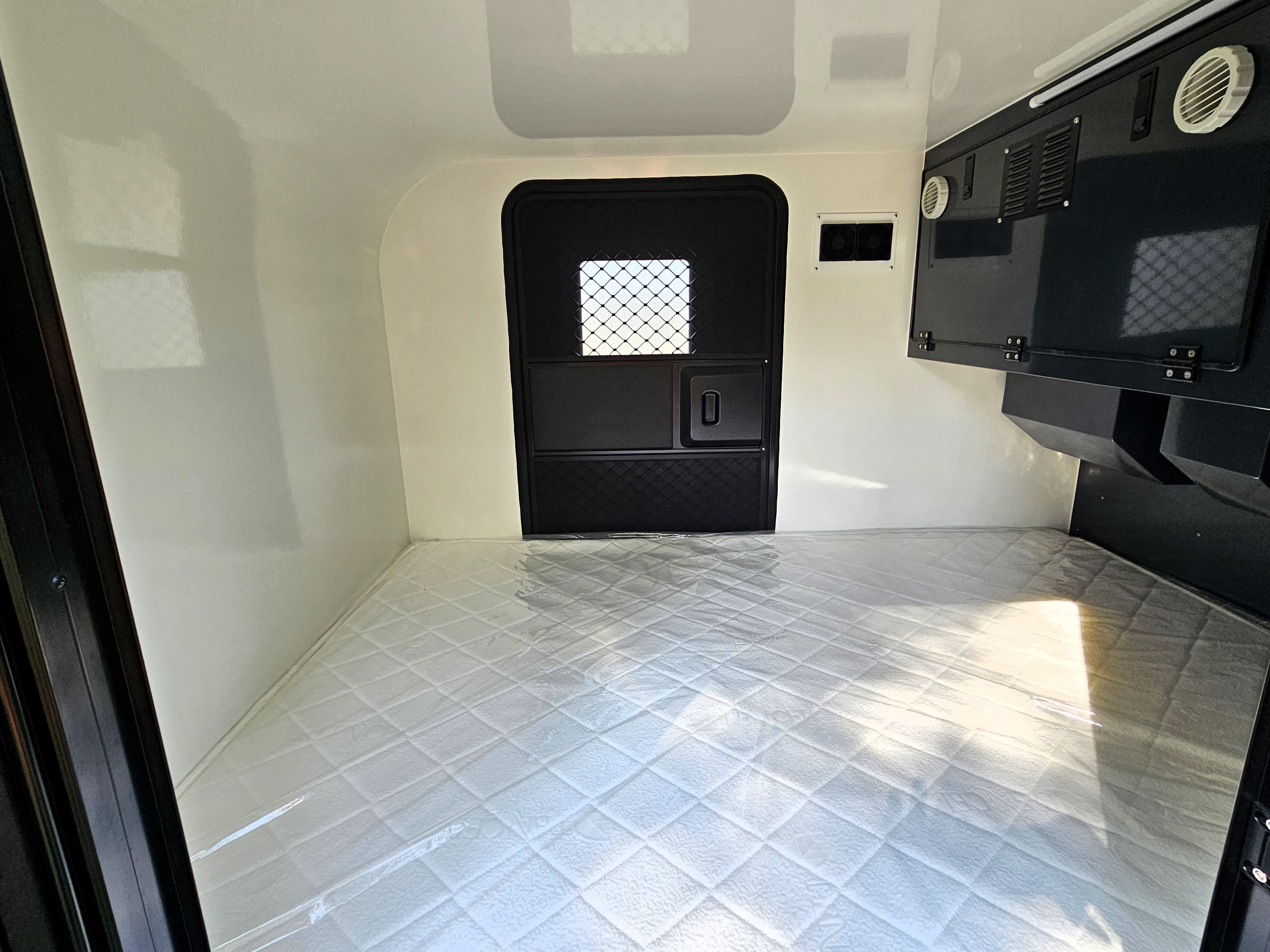 Clean RV rental interior featuring a cozy mattress and compact sleeping area, ready for adventure.. OTG Campers Voyager X 2024