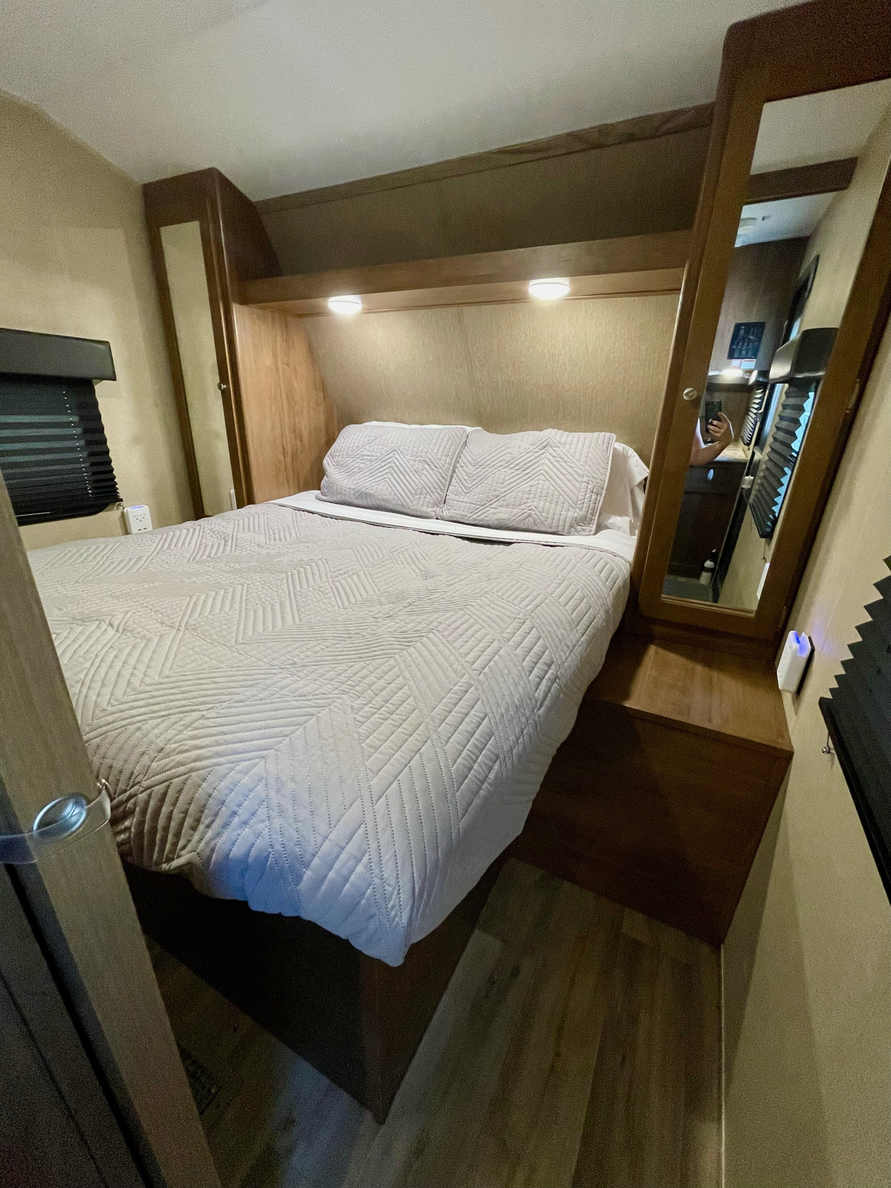 This RV rental bedroom features a quilted bed, built-in lighting, and a mirrored cabinet, maximizing comfort.. Dutchmen Aspen Trail 2017