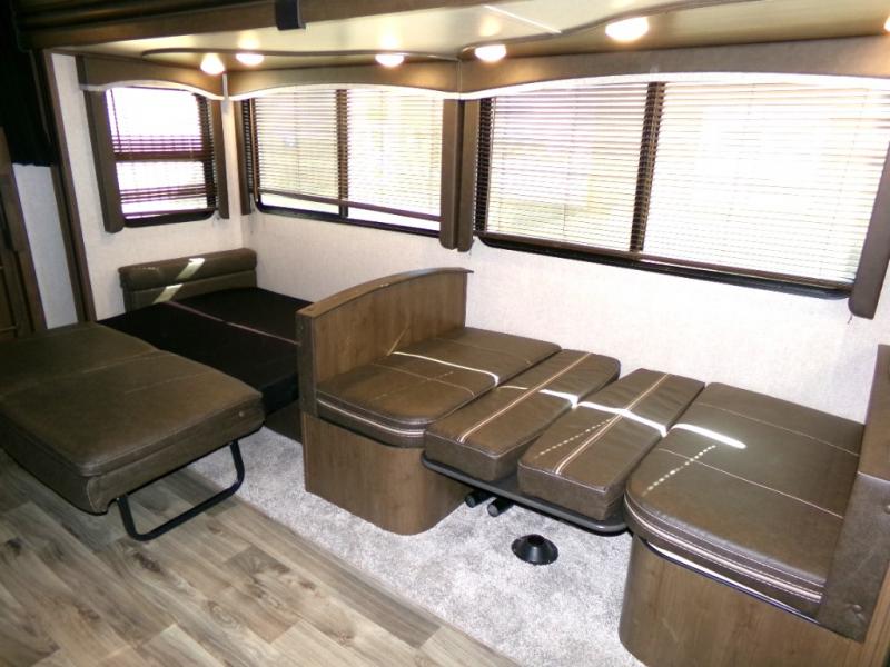 Spacious RV rental interior features convertible dinette seating, an additional lounge bed, and bright windows.. Keystone RV Cougar 2019