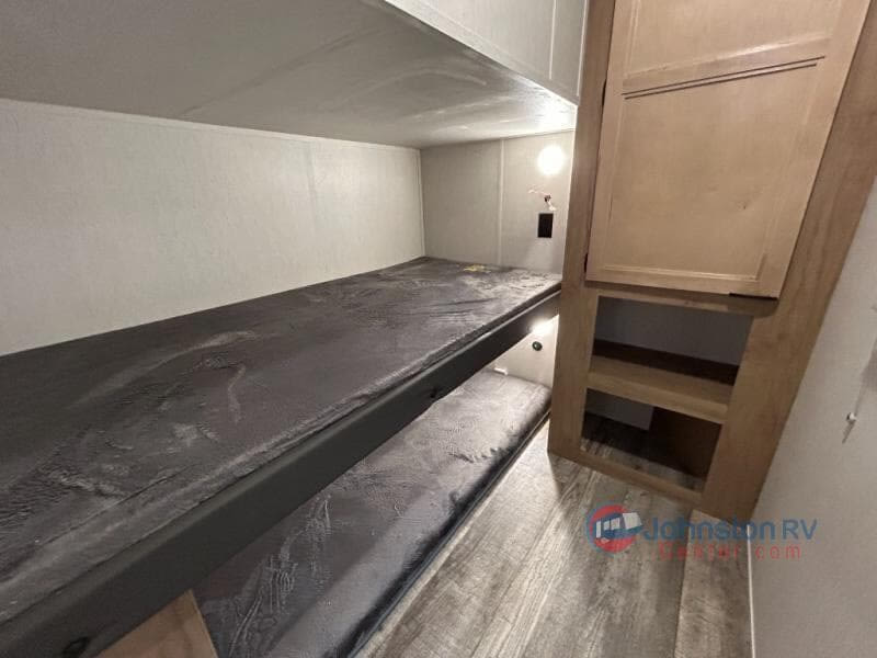 This RV rental features cozy bunk beds & a storage cabinet. Perfect for family adventures, this camper interior maximizes space.. Forest River Cherokee 294GEBG 2024