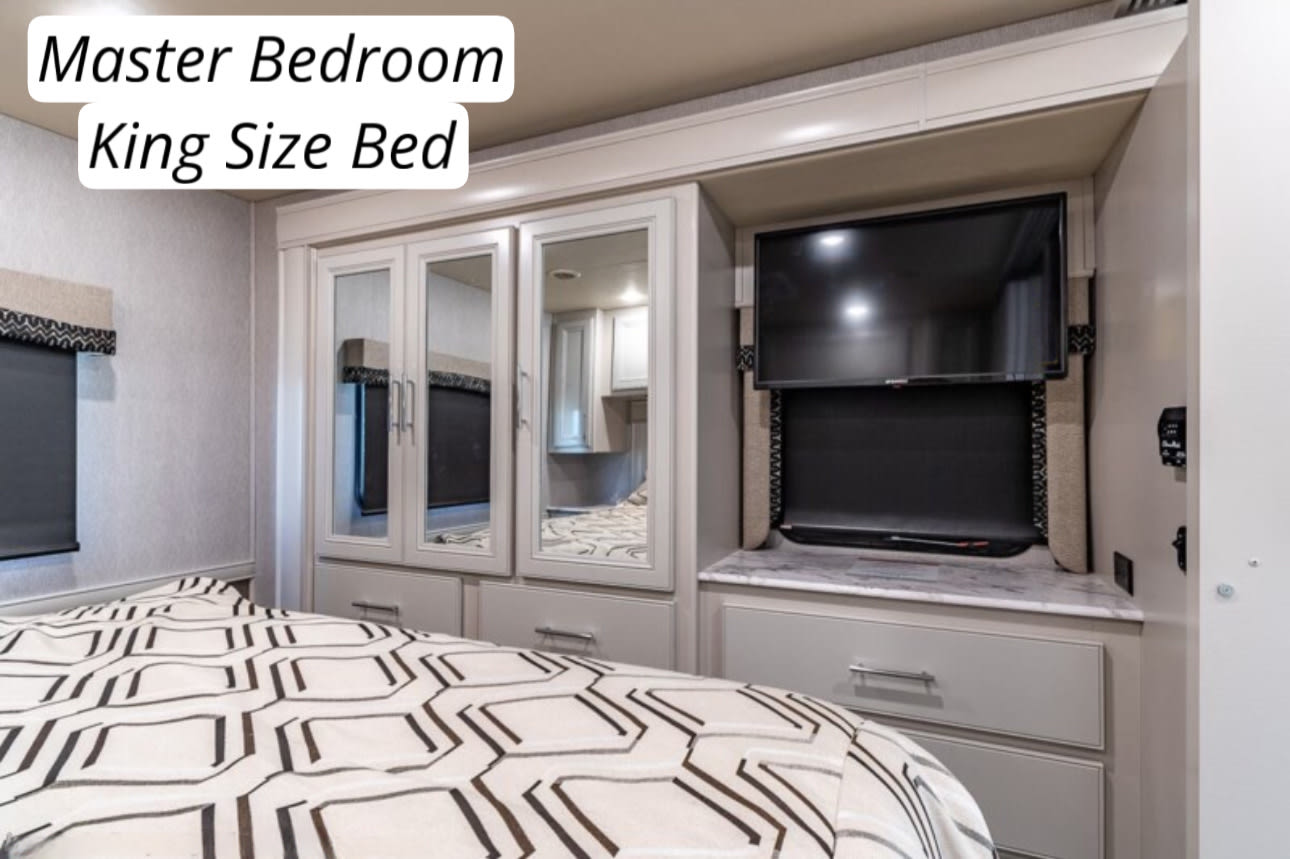 Master bedroom in this RV rental offers a king-size bed, mounted TV, and built-in storage.. Flair-Fleetwood Flair-Fleetwood Motorhome 2022