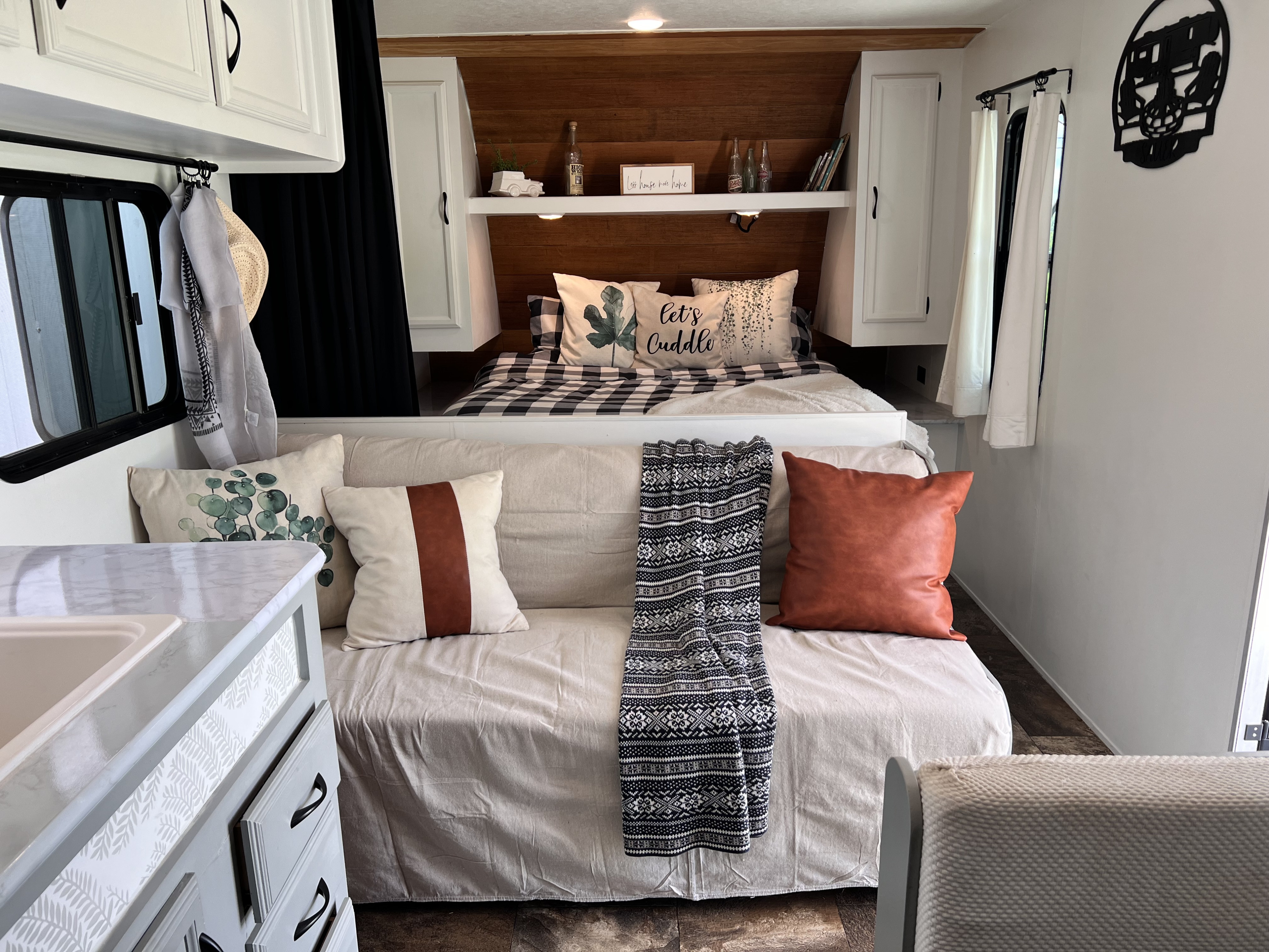 Inside a modern farmhouse RV rental, showcasing a cozy bed, sofa lounge, and custom built-in decor.. Starcraft AR-One Maxx 2016