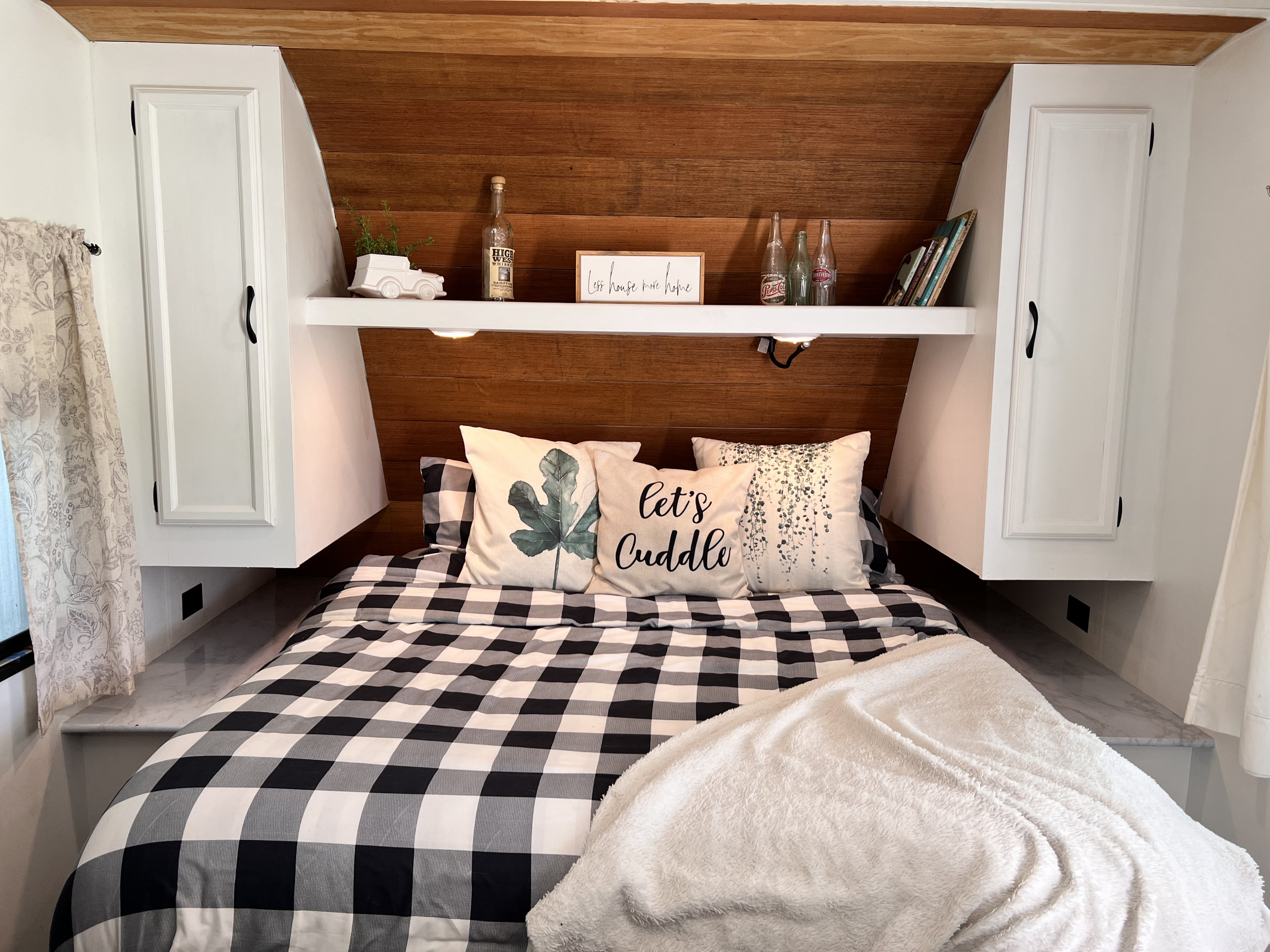 Inviting RV rental bedroom with black and white buffalo check bed, accent pillows, and decorated wooden headboard.. Starcraft AR-One Maxx 2016