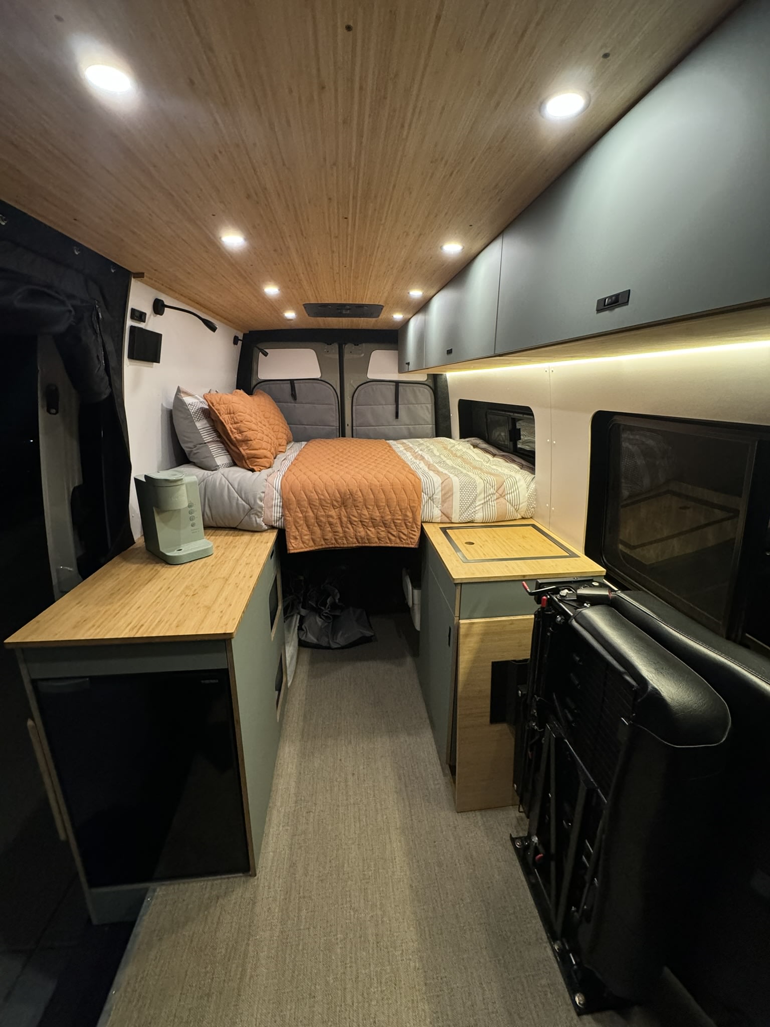 Experience a modern RV rental interior with a cozy bed, sleek kitchen, and intelligent storage solutions.. Geotrek Geotrek Class B 2024
