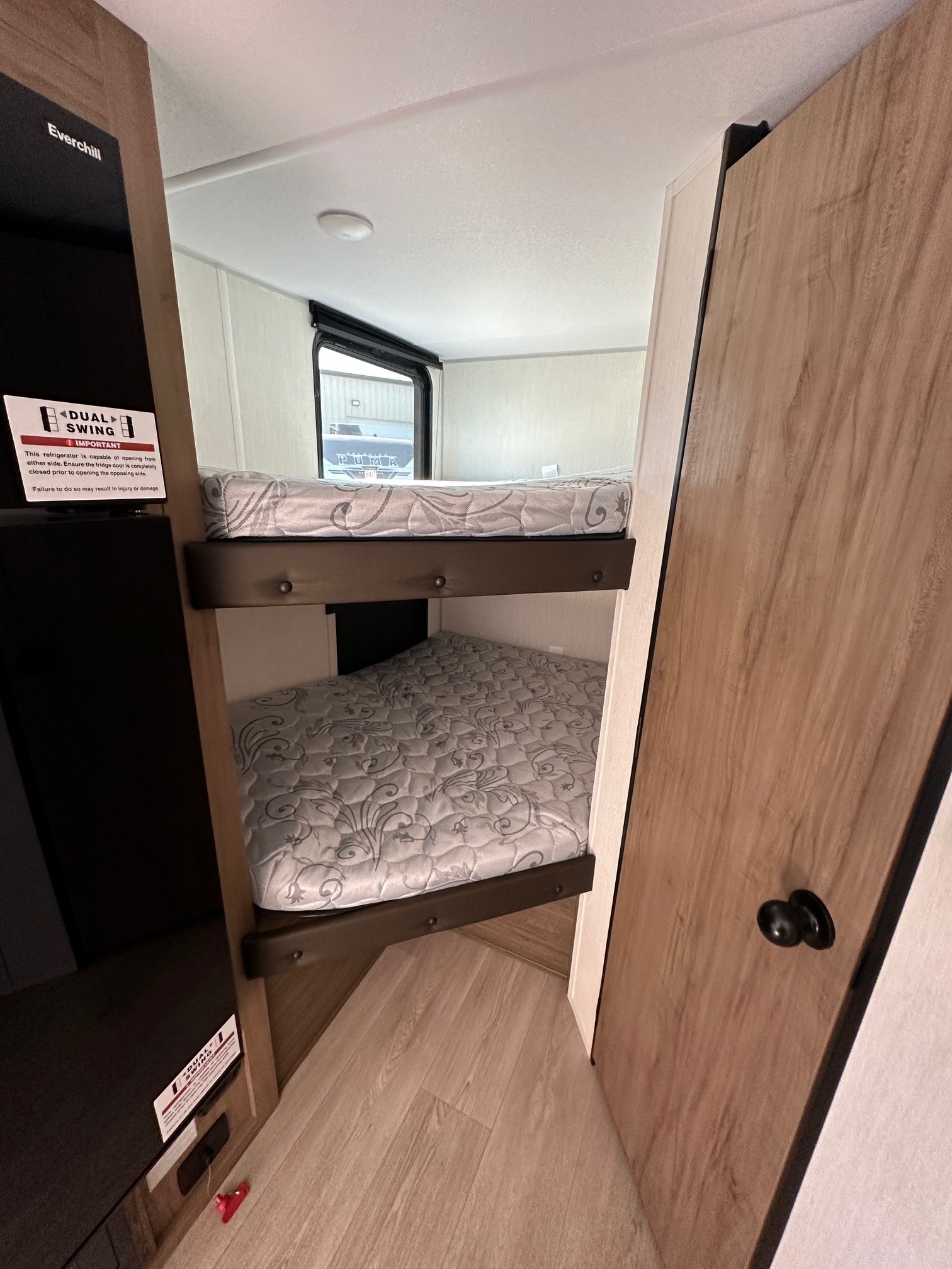 This RV rental interior features comfy bunk beds and an Everchill dual-swing refrigerator, ideal for family trips.. Forest River Cherokee Wolf Pup 2025