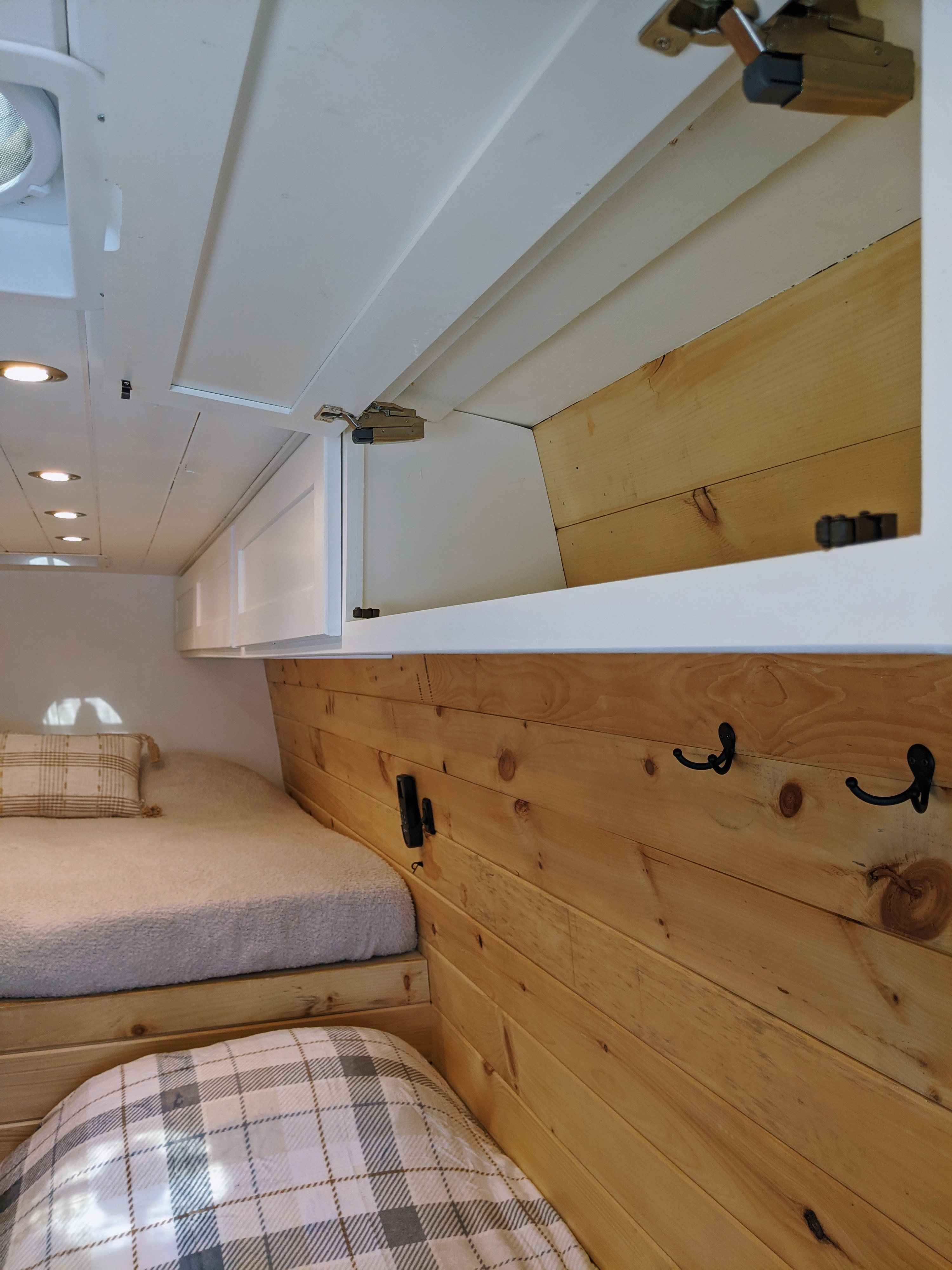 RV rental: Bright interior featuring stacked beds, natural wood paneling, and white overhead storage cabinets.. Sprinter Mercedes 2018