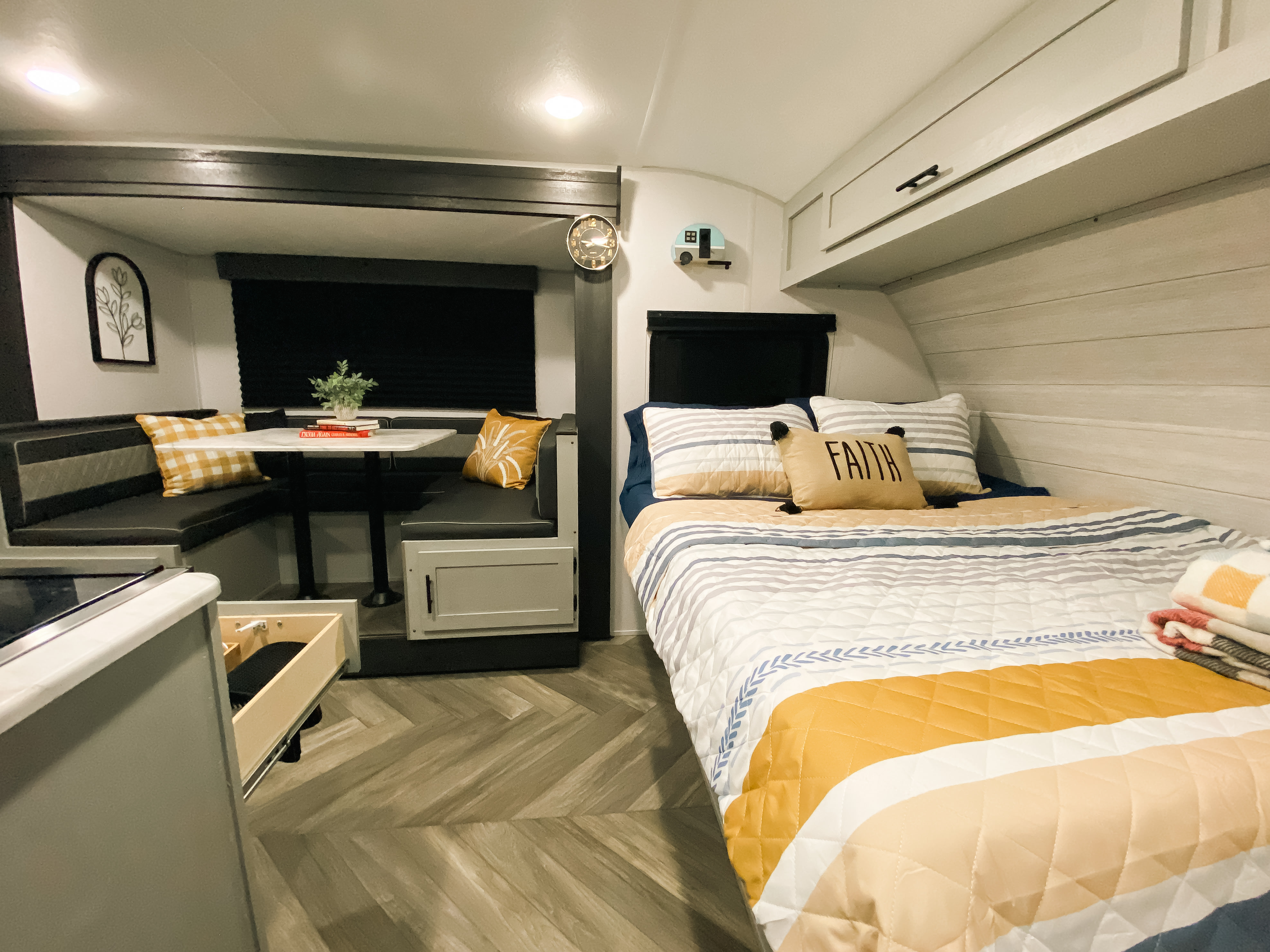 Bright & modern RV rental interior with a comfy bed, striped bedding, and a cozy dinette area.. Forest River Salem FSX PLATINUM 2021