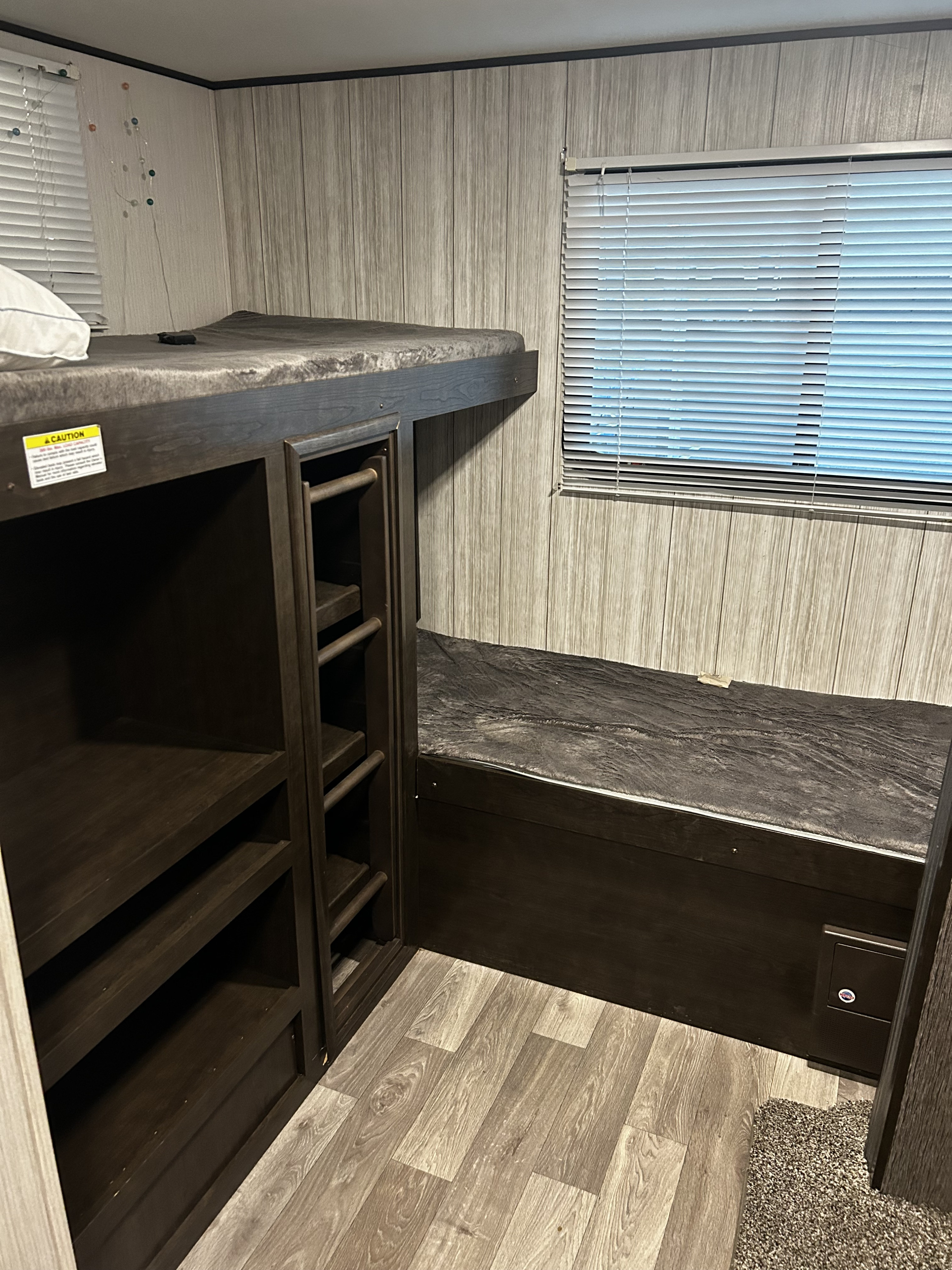 RV rental interior: cozy bunk beds with integrated storage shelves and a functional bench seat by the window.. Heartland RVs Pioneer 2020