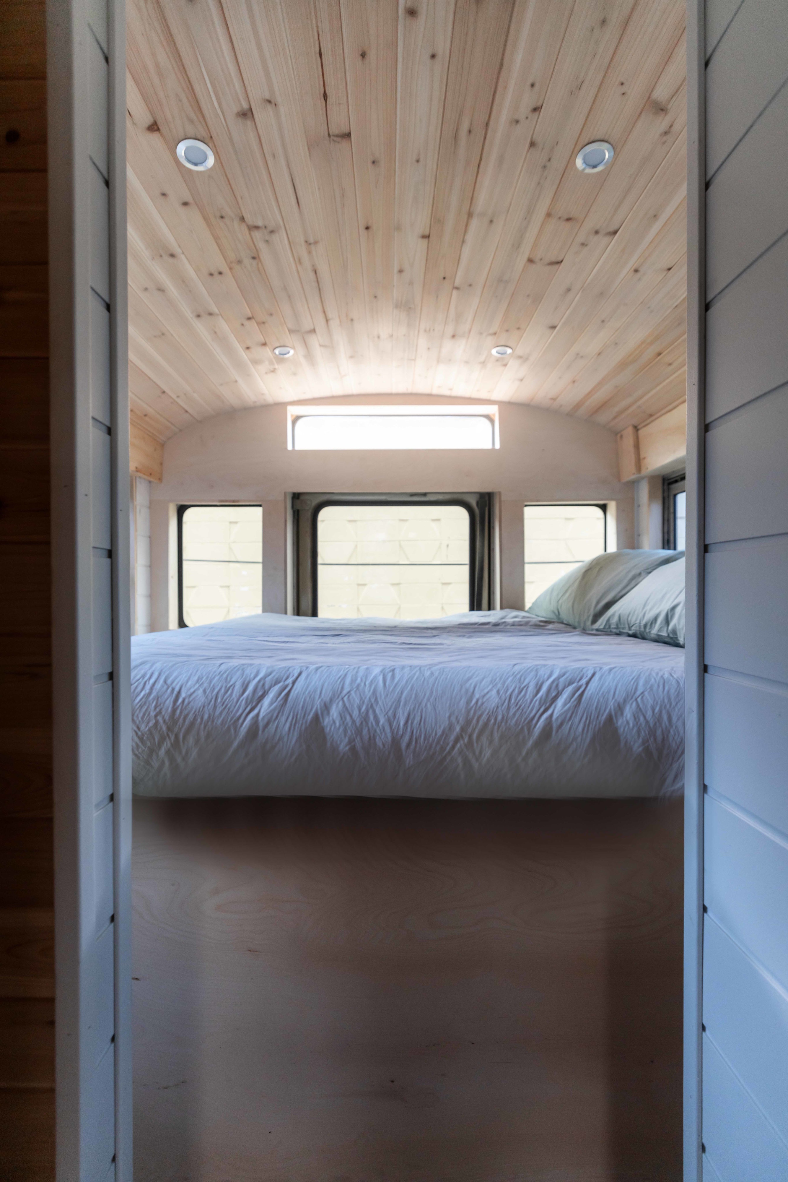 Step into this modern RV rental's bedroom.. Inter Skoolie 2007