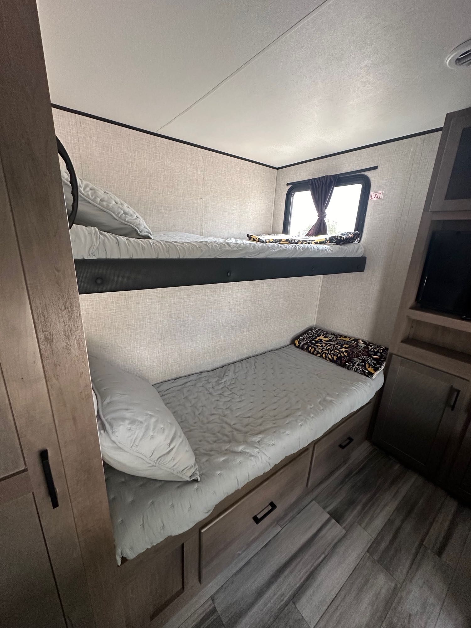This RV rental features comfy bunk beds, a window, and storage, creating a cozy sleeping area for your trip.. Jayco Jay Flight 2024