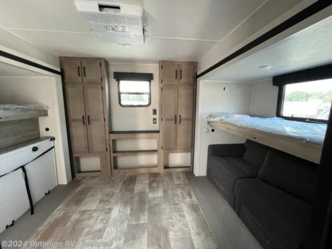 Spacious RV rental interior features wood-look floors, bunk beds, a sofa, and light wood storage cabinets.. Forest River Palomino Puma 2022