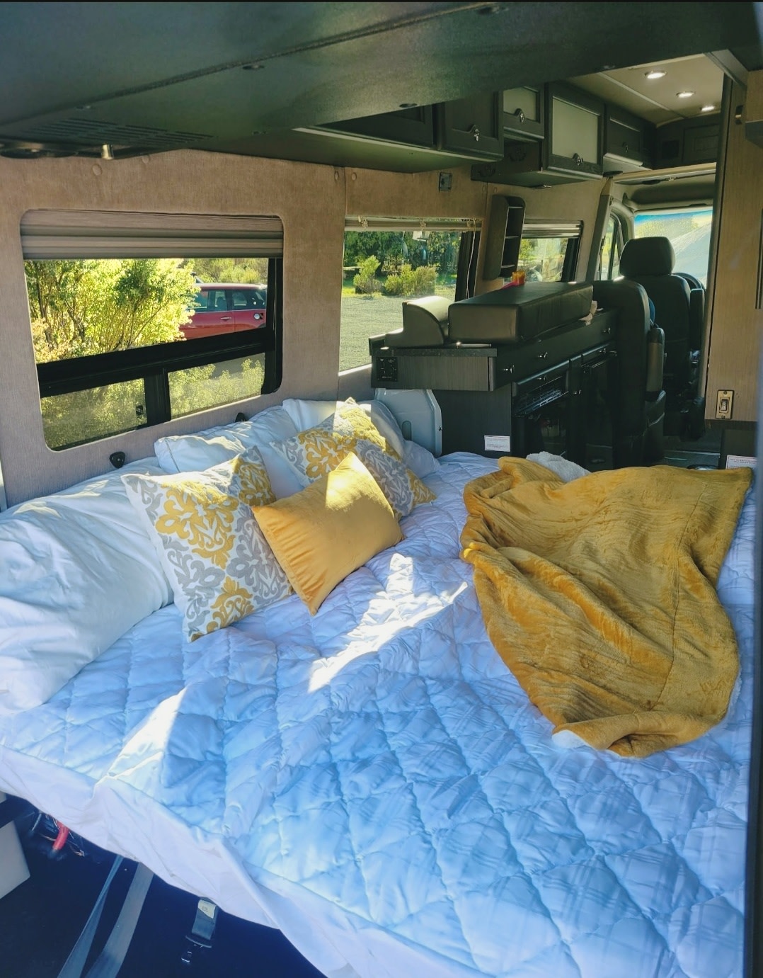 Cozy RV rental interior featuring a large bed, comfy pillows, and scenic window views.. Roadtrek Roadtrek Class B 2017