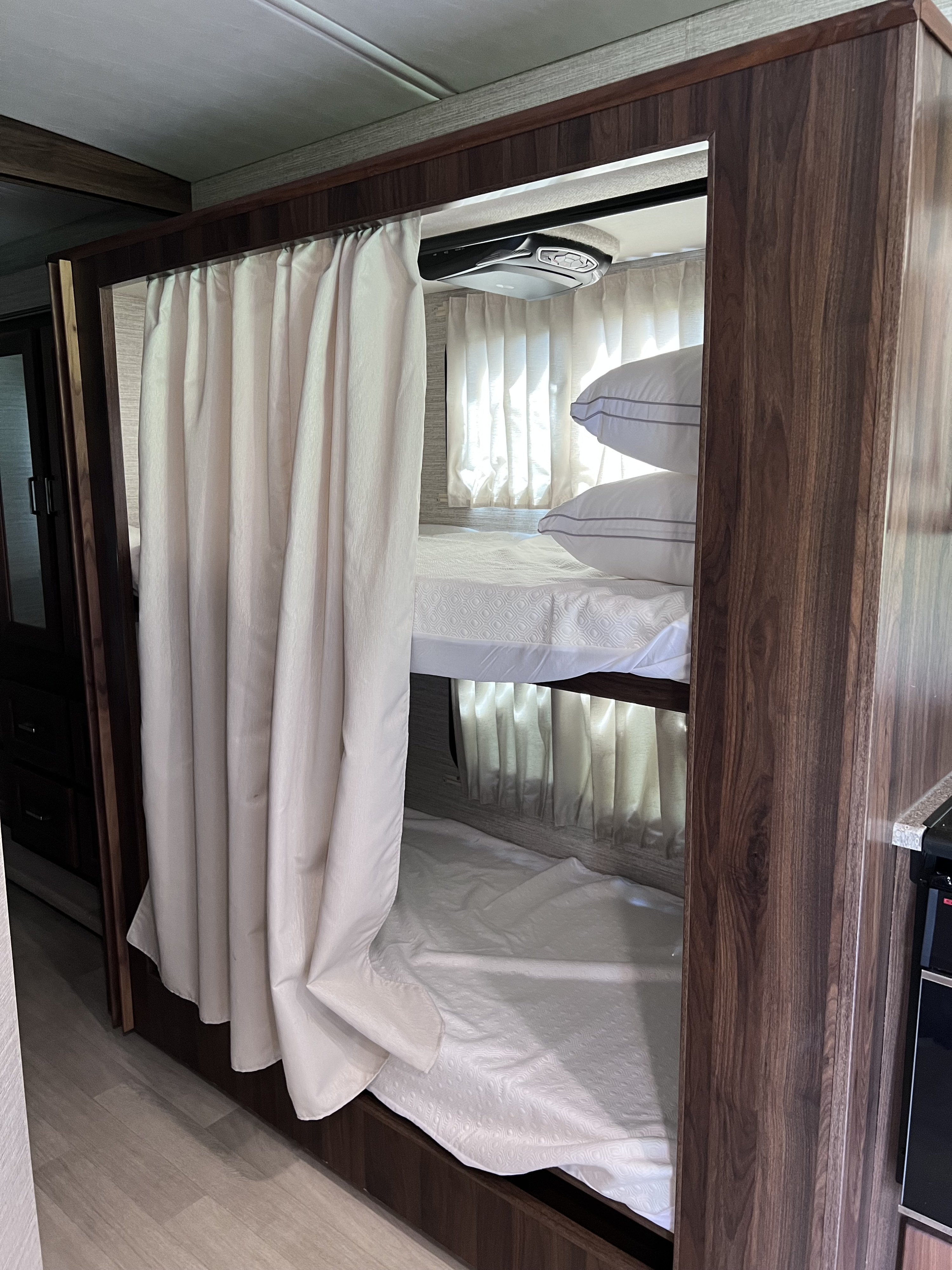 RV rental's bunk beds feature privacy curtains, plush pillows, and a ceiling-mounted entertainment unit for comfort.. Winnebago Vista 2021