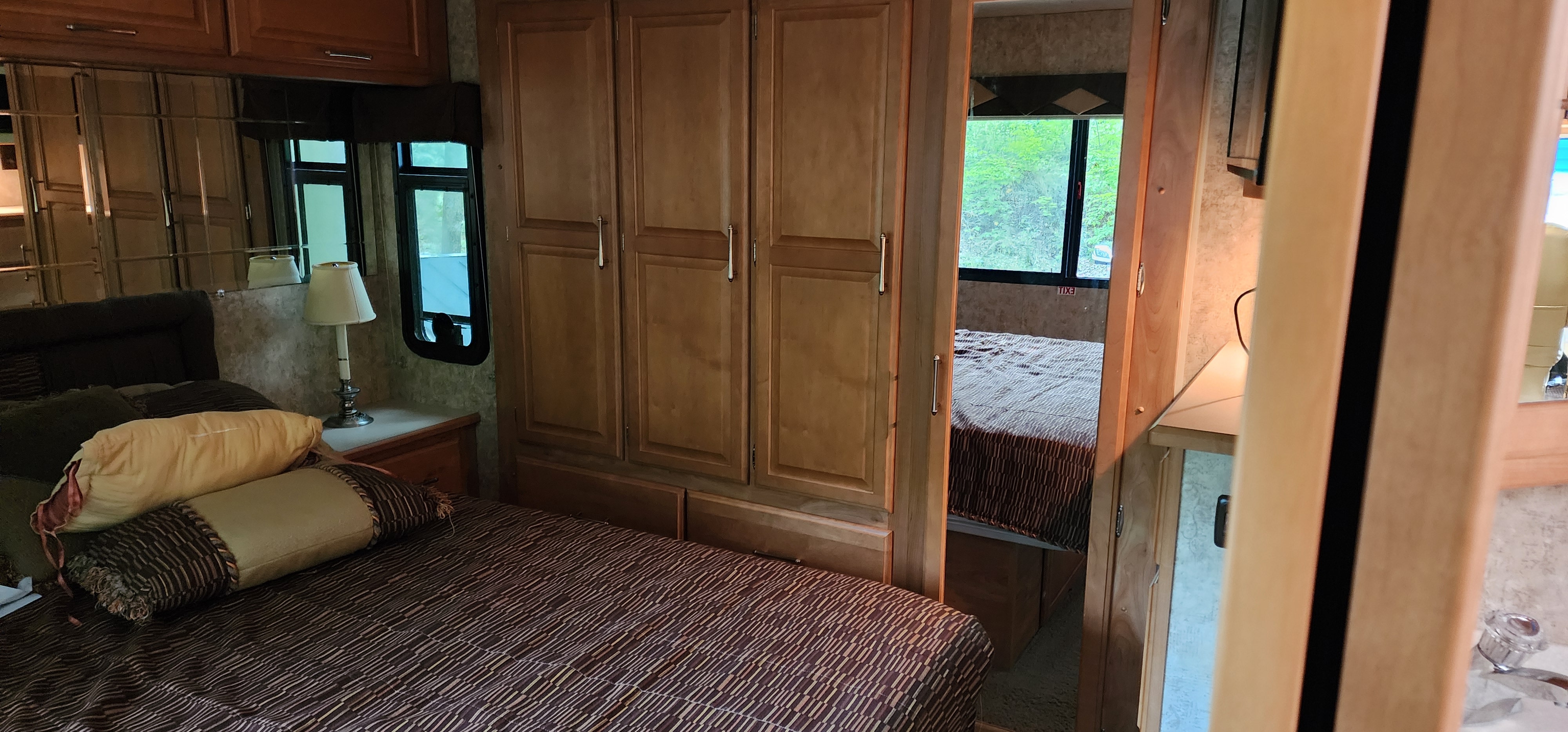 RV rental: Spacious interior showing a cozy bedroom with mirrored cabinets and a second bedroom visible through the doorway.. Winnebago Journey 2006