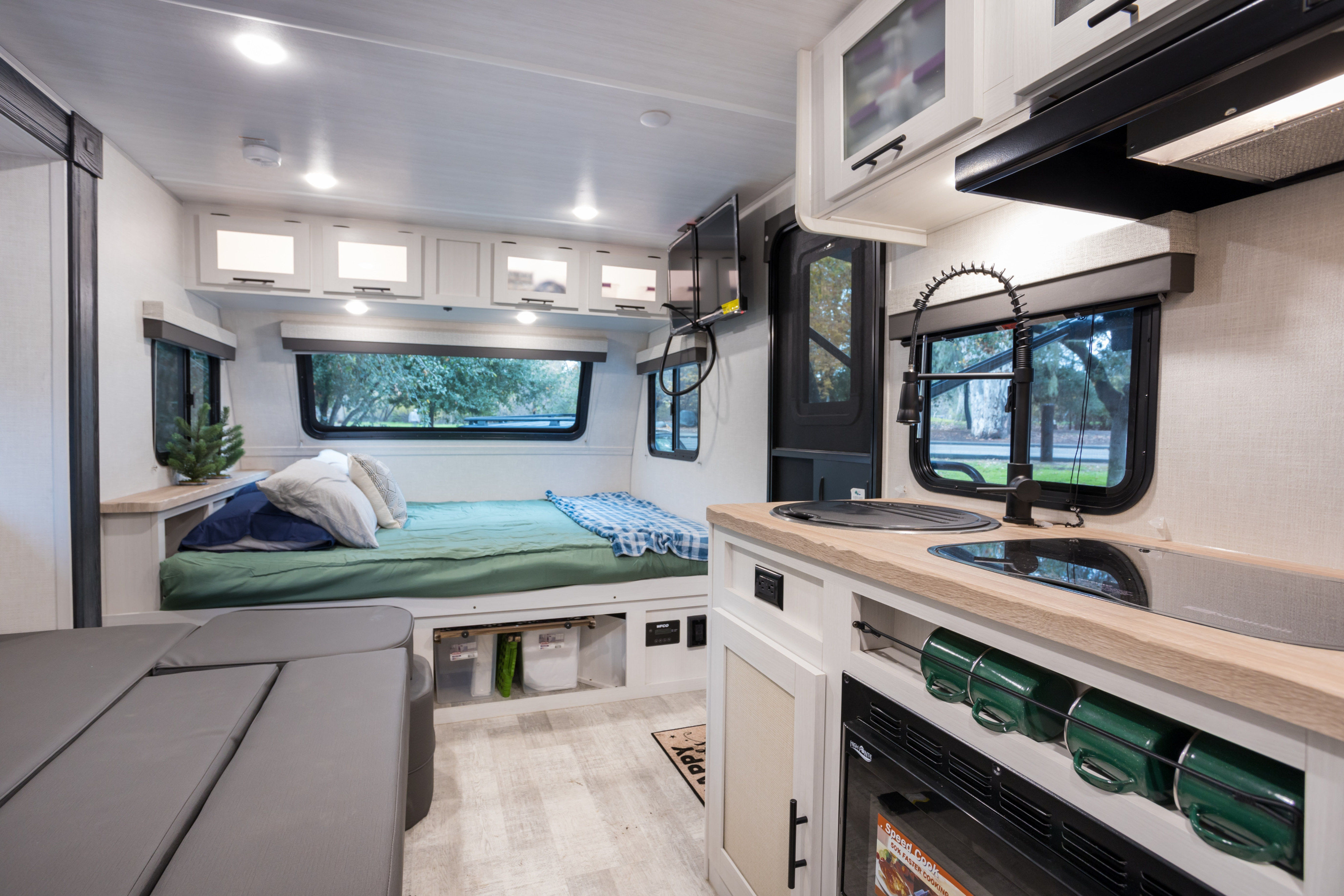 Inside this RV rental: a compact yet complete living space with a comfy bed, kitchen, and seating area.. No Boundaries 19 2023