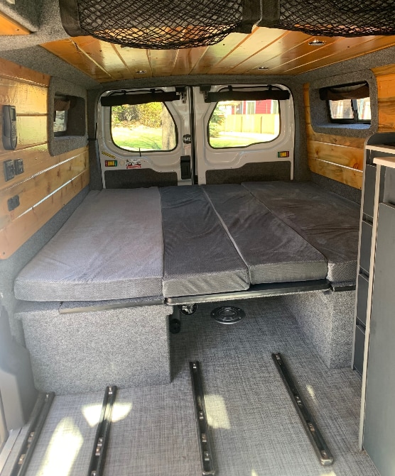 RV rental ready: This camper van features a modular bed/seating area, under-bed storage, and wood-paneled interior.. Ford Transit Custom 2019