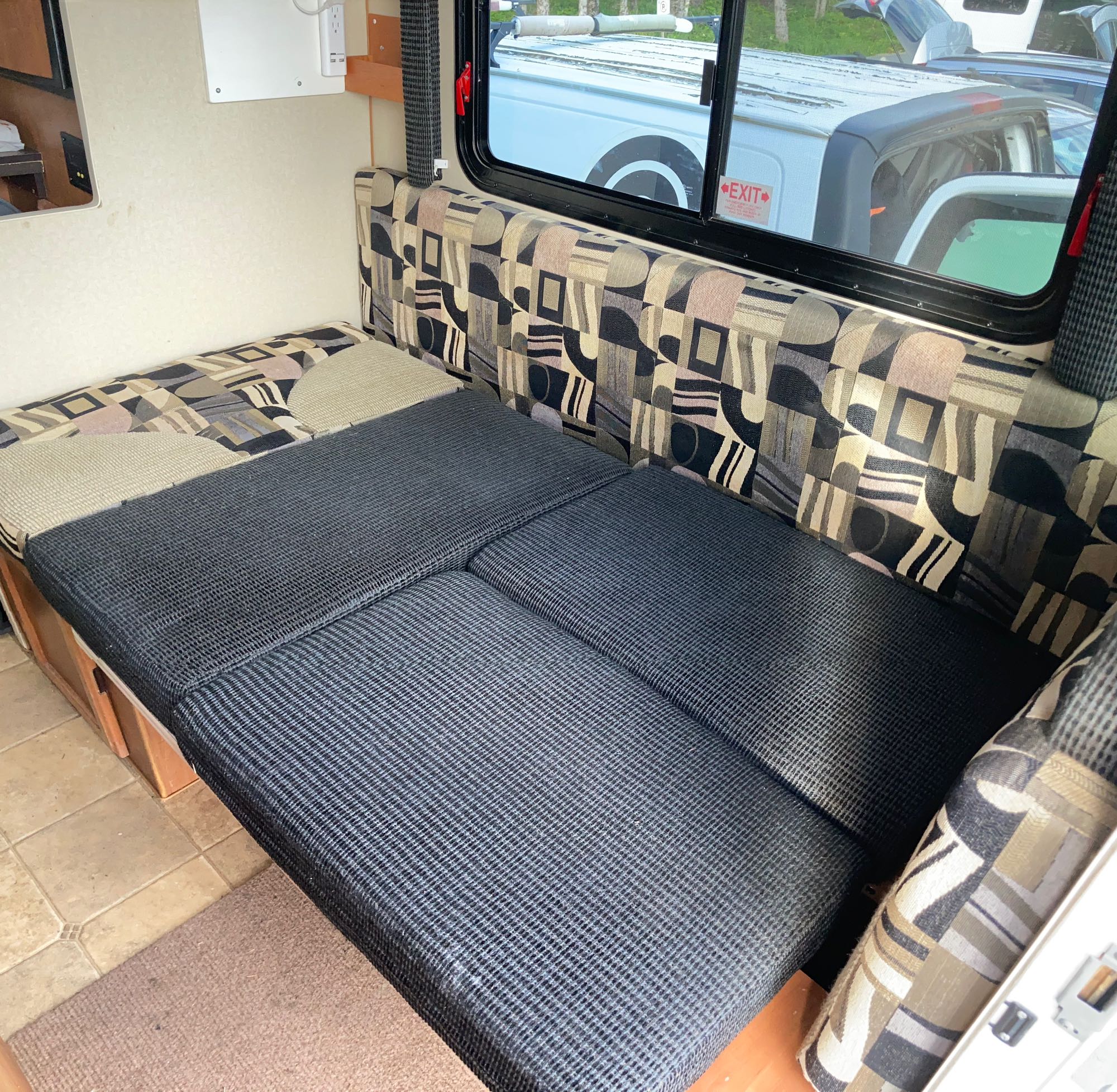 RV rental dinette converts to a bed, showing comfy seating, power outlets, and window views for your next road trip.. Dodge RAM 3500HD 2010