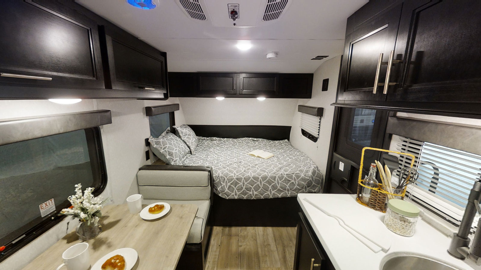Cozy RV rental interior with a comfy bed, dining nook, and compact kitchen. Perfect for travel adventures.. Forest River Cherokee Wolf Pup Black Label 2022