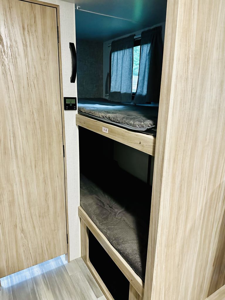 Inside this RV rental: two bunk beds with mattresses, a window, and a control panel. Perfect for your camper adventures.. Winnebago Minnie Winnie 2021