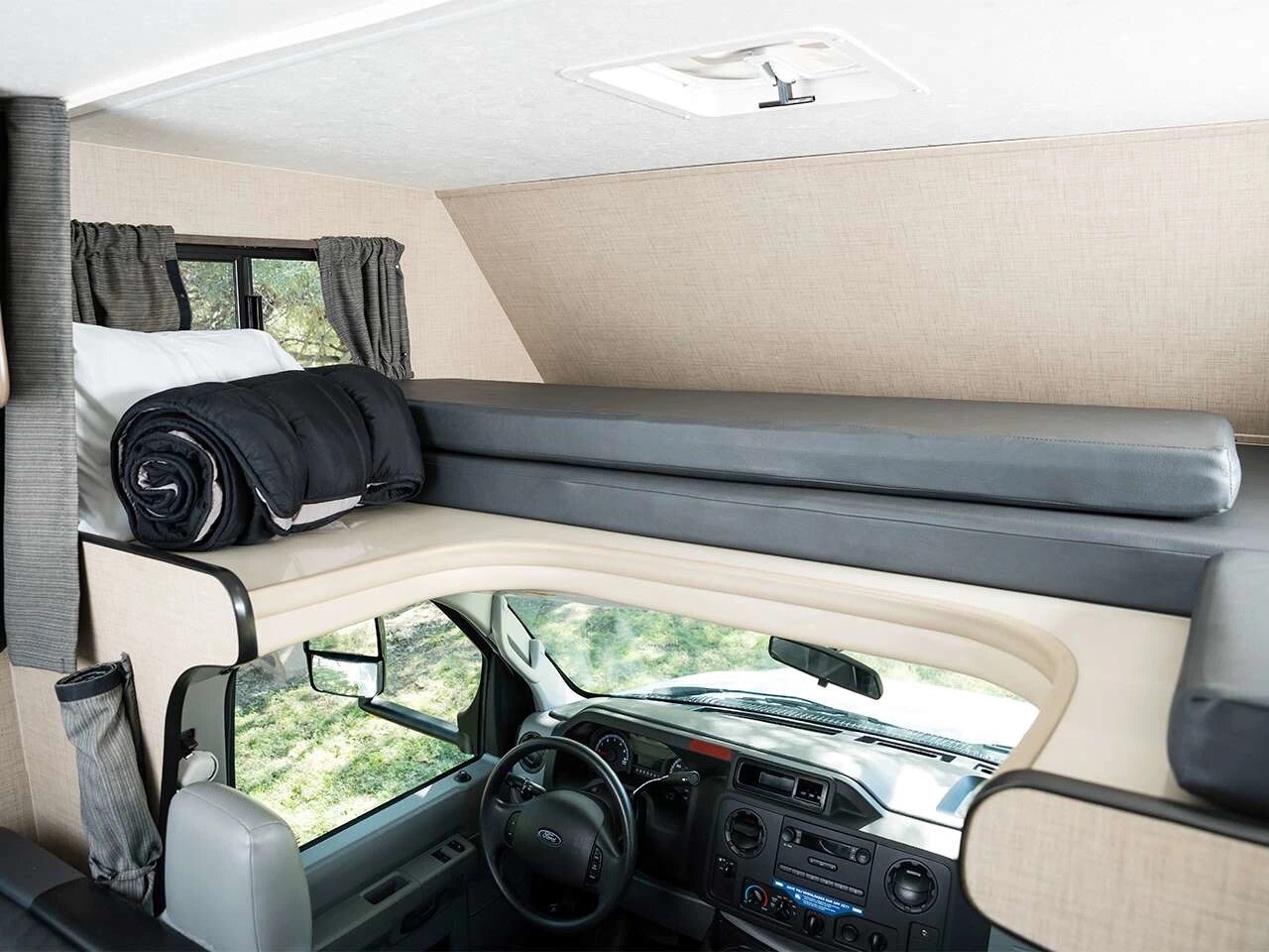 Spacious RV rental interior: over-cab bunk, comfy sleeping area, and driver's cab. Perfect for road trips.. Thor Majestic 2019