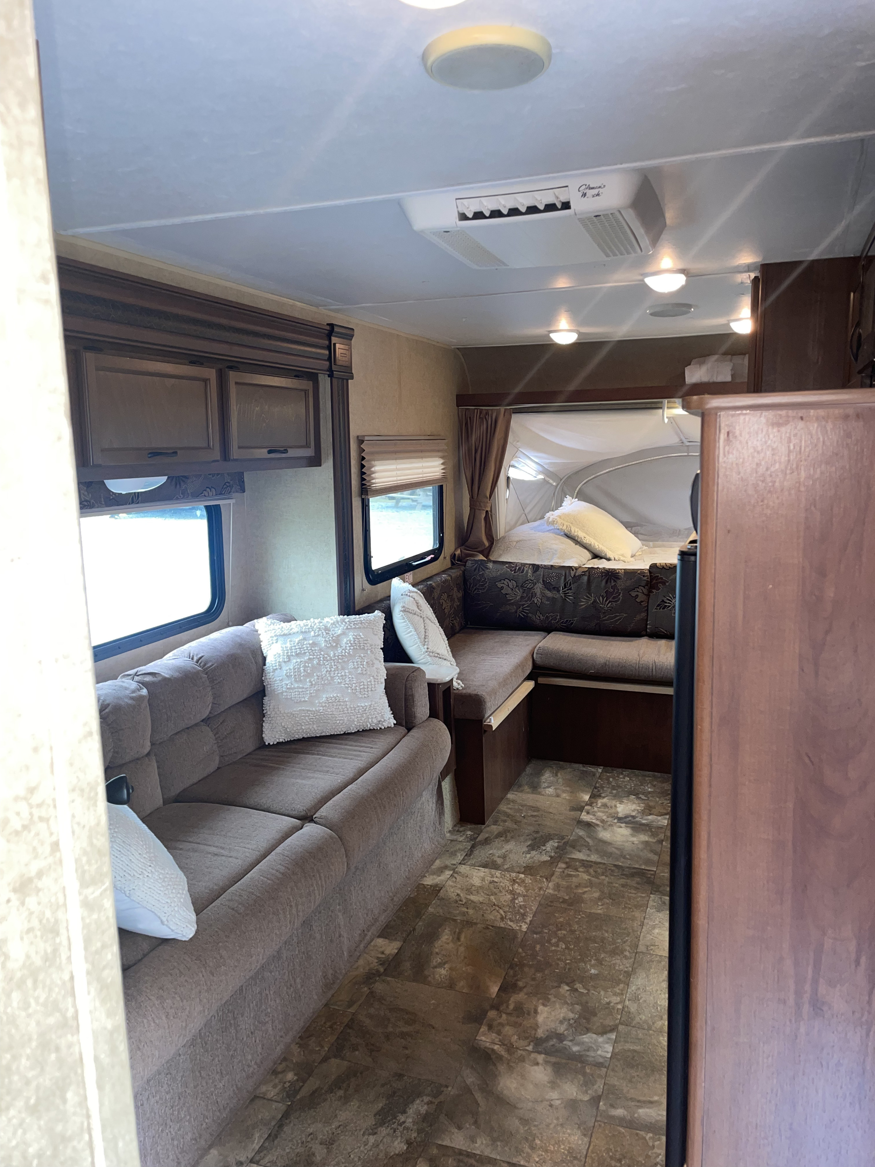 Inside an RV rental: A comfy couch, a convertible dinette seating, and a fabric-sided pop-out bed area offer flexible living and sleeping.. Jayco Jay Feather Ultra Lite SLX 2014