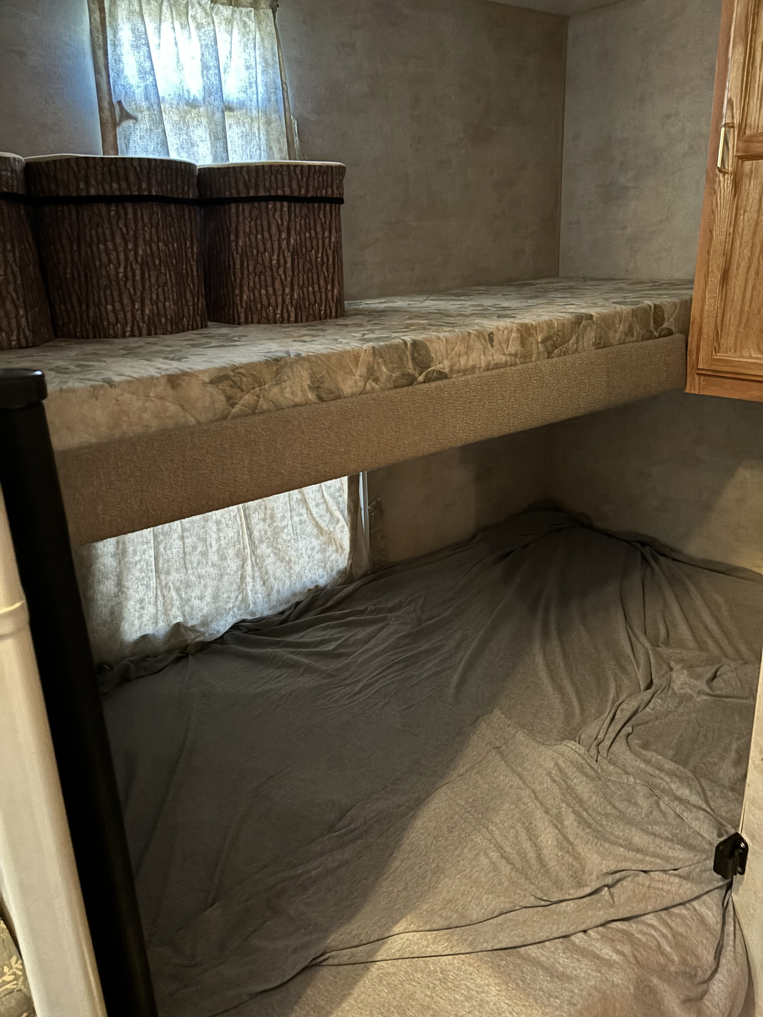 RV rental bunk beds offer a cozy sleeping space. Features include log-style bolsters and a window. Ideal for travel.. Jayco Jay Flight 2004