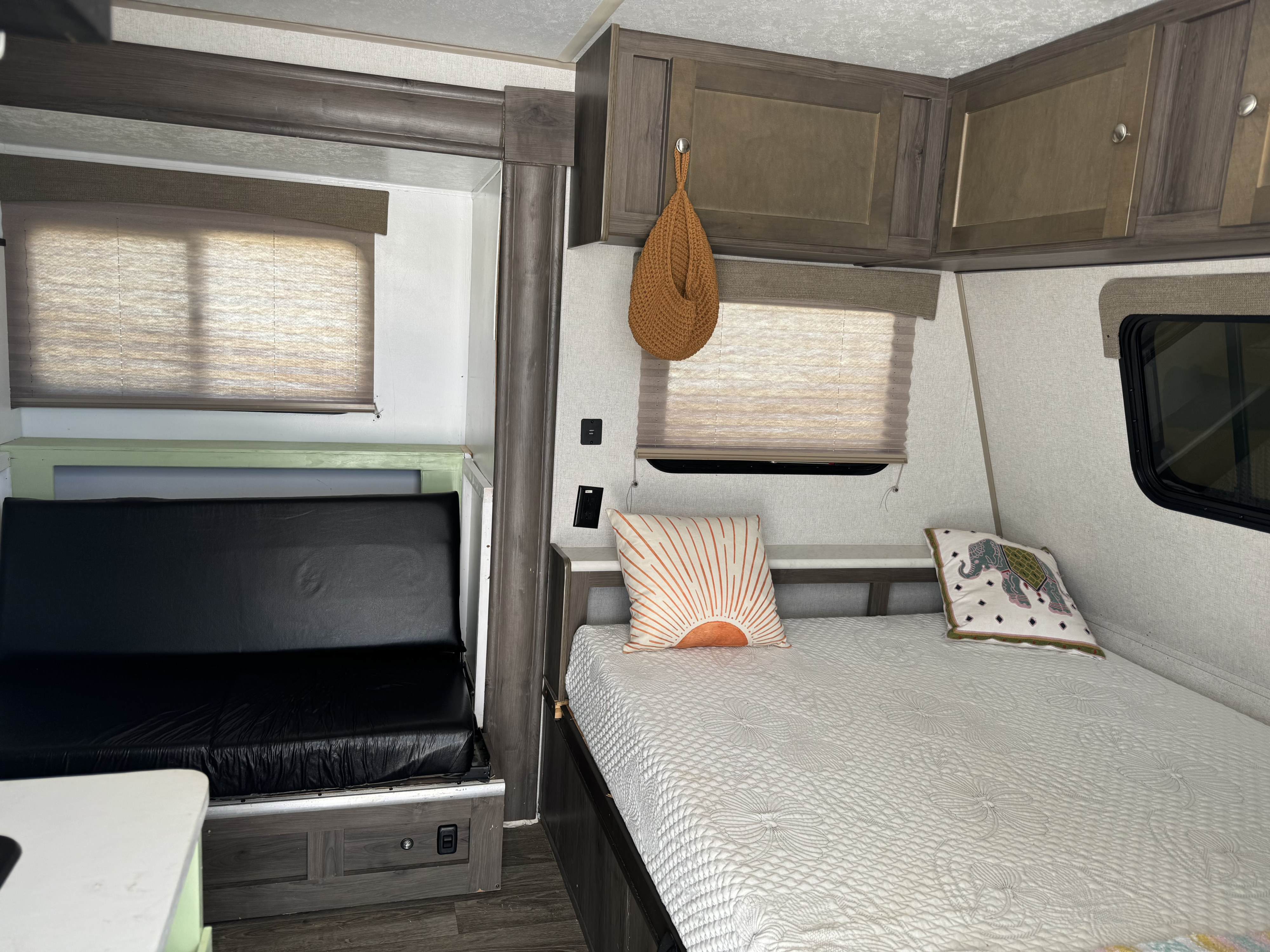 Experience comfort in this RV rental! Features a serene bedroom with a cozy bed, decorative pillows, and a versatile bunk.. Forest River Viking 2019